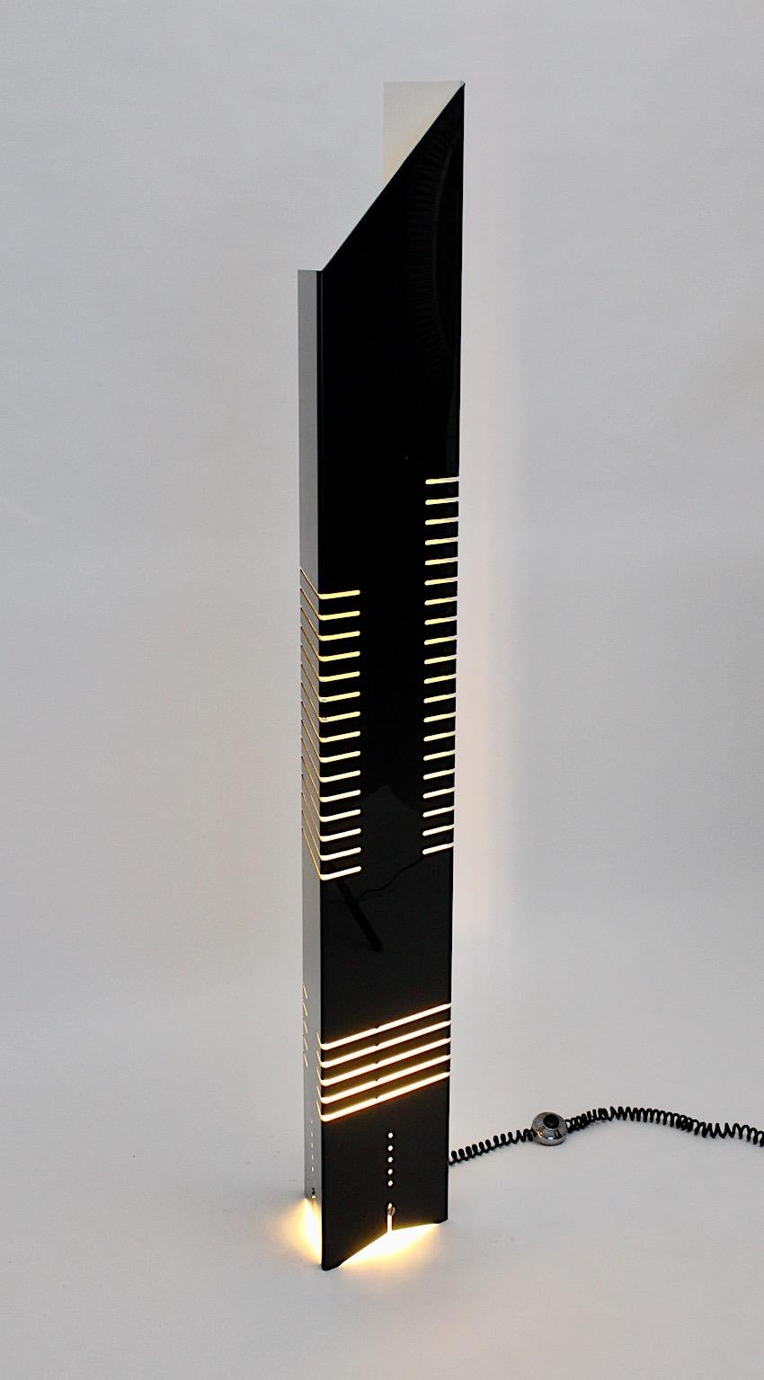 Black vintage metal floor lamp, which was designed by Lorenzo Carmellini and Frederico Rezzonico for Tronconi 1972 Italy.
The triangle shaped floor lamp is composed of black sheet metal body with cutouts and covered with acrylic. The folded acrylic