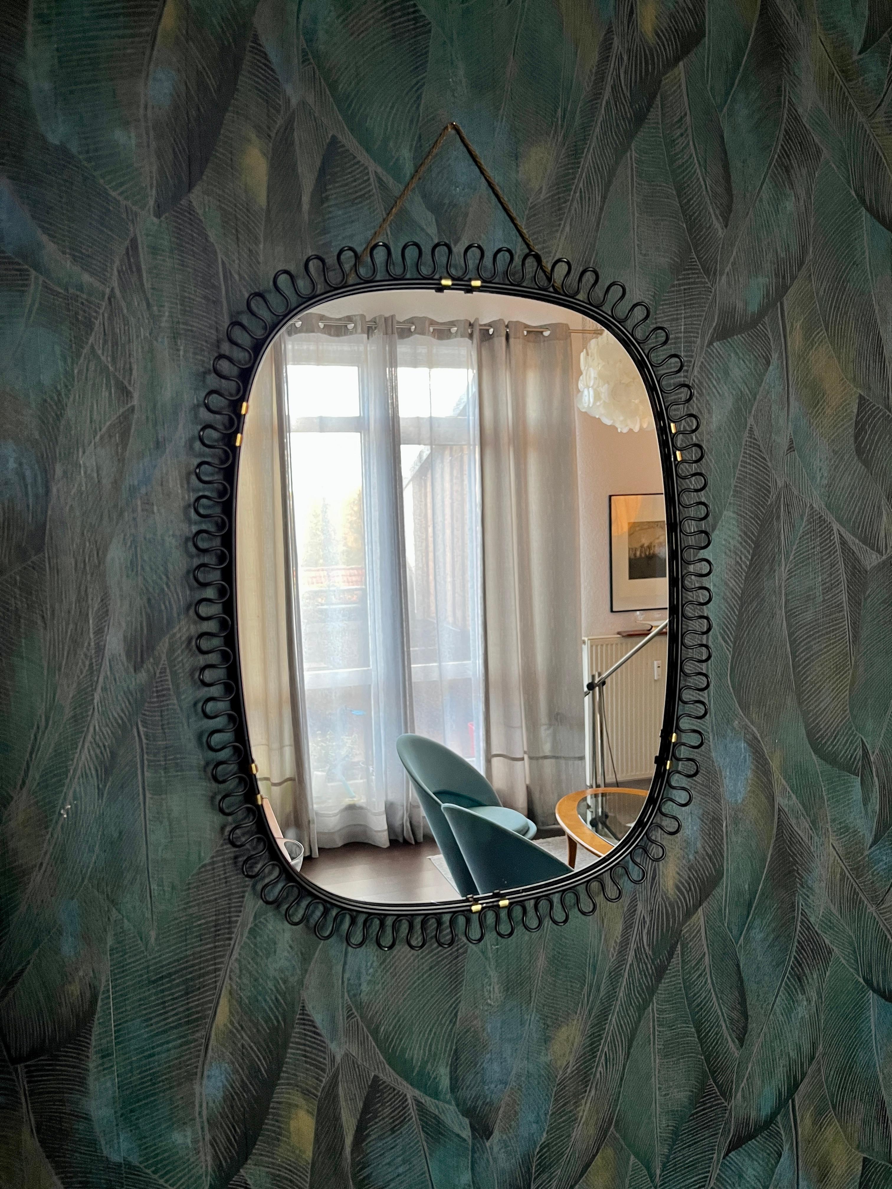 Un miroir délicat avec un fin cadre en boucle en laiton (peint en noir).
Un classique absolu du design des années 1950. Ce miroir en laiton a été conçu par le designer autrichien Josef Franks pour la célèbre société de design suédoise Svenskt