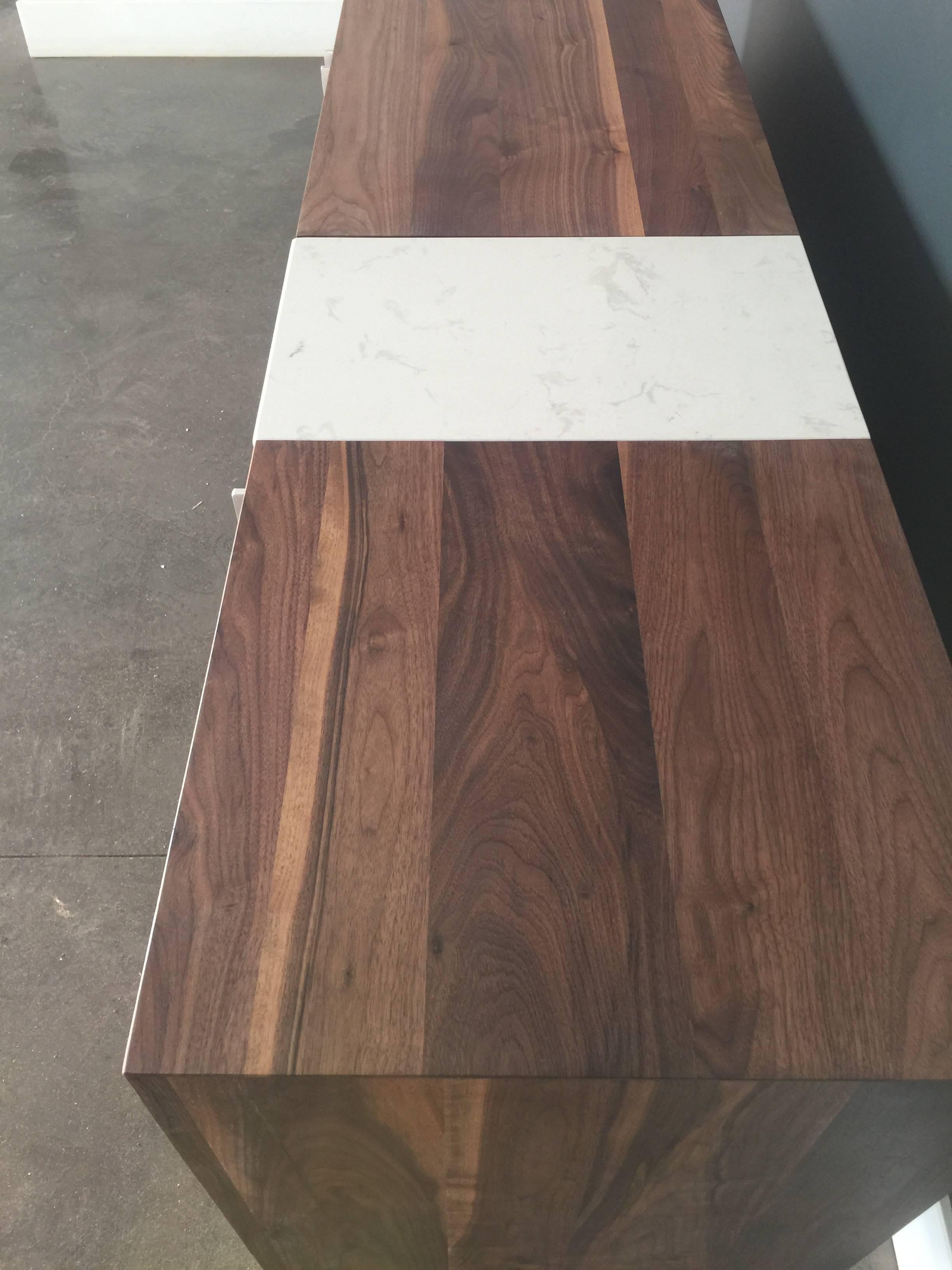 Each dining room needs a credenza. This black walnut credenza is all solid wood. It has three doors with aluminum and sits on an aluminum legs. It has a quartz section.  This piece is an heirloom that your family will pass down from generation to