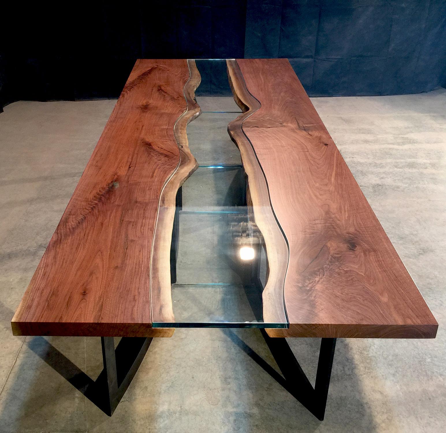 Dining table 2 1/4? live edge black walnut and 3/4? glass center with bronze patina steel base.