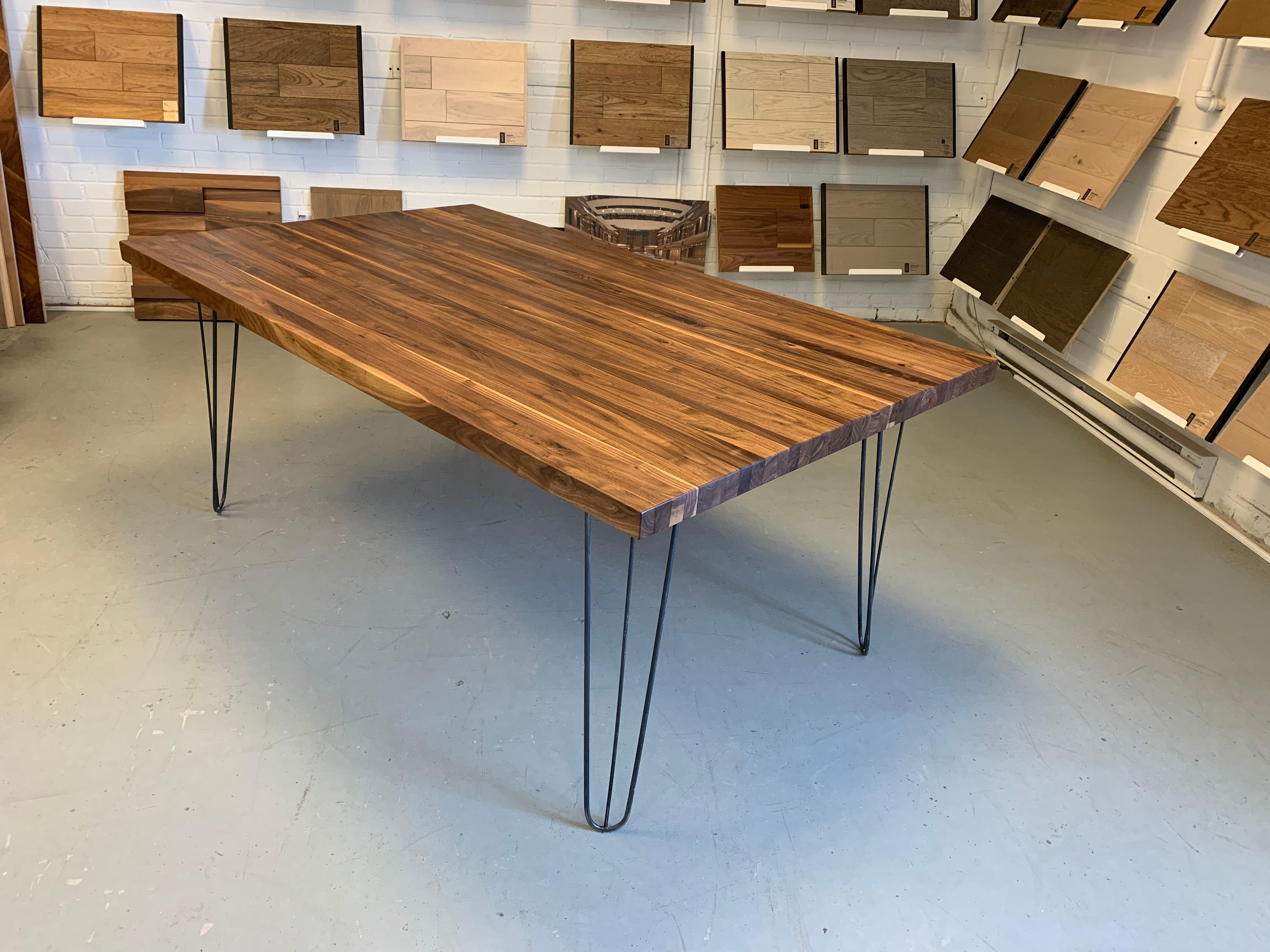 This black walnut dining table is a laminated tabletop using 1in 1/4 strips. It is 2in thick. It sits on hairpin legs but we can make any legs style. We offer any color match stain. We make the sample and send it to you for approval. 

Bois & Design