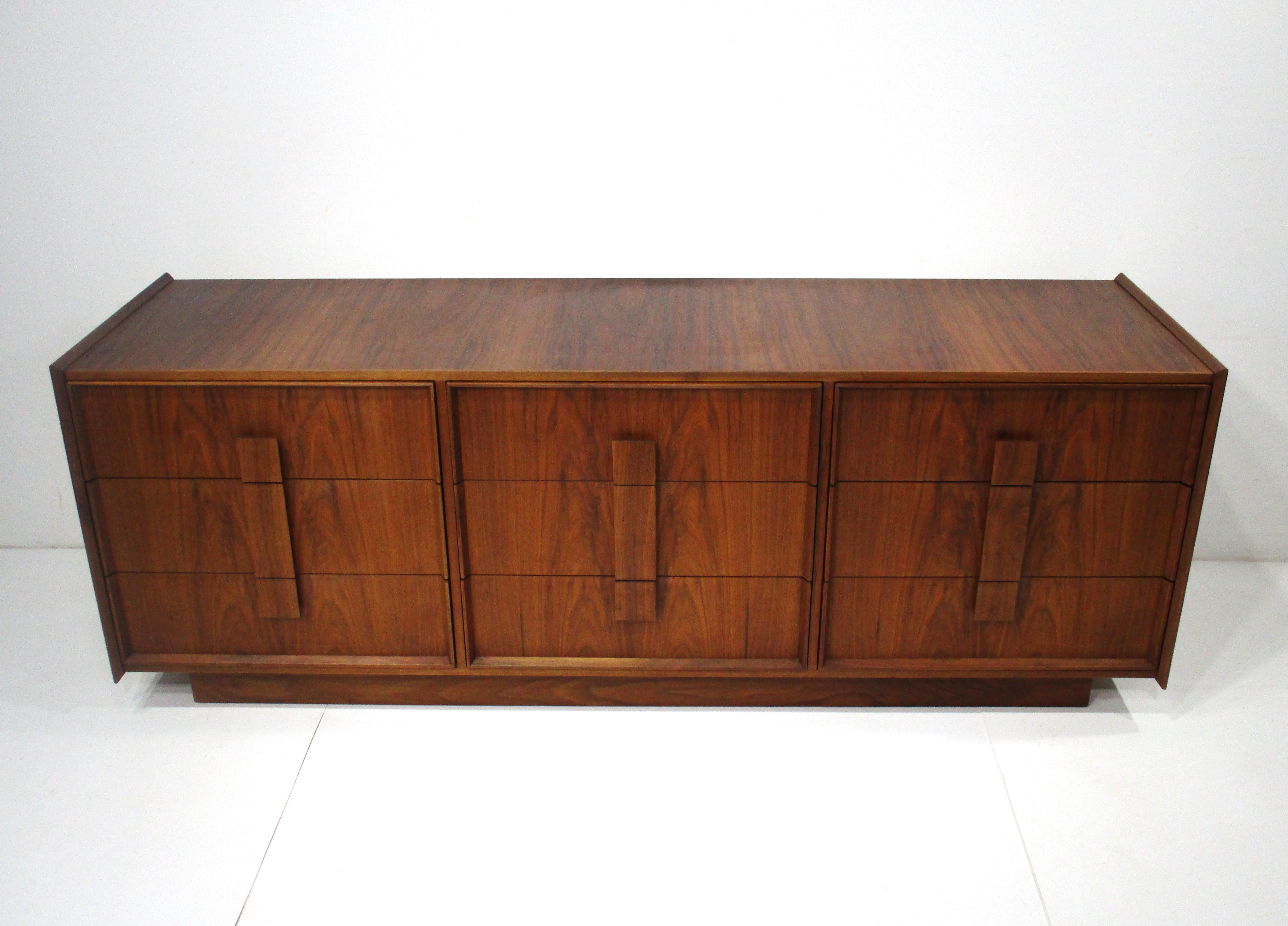 A very well crafted American black walnut nine drawer dresser chest with wonderful book matched flamed graining . The edges of the piece are raised and the squared pulls make opening easy . Designed in the manner of the George Nakashima studio with