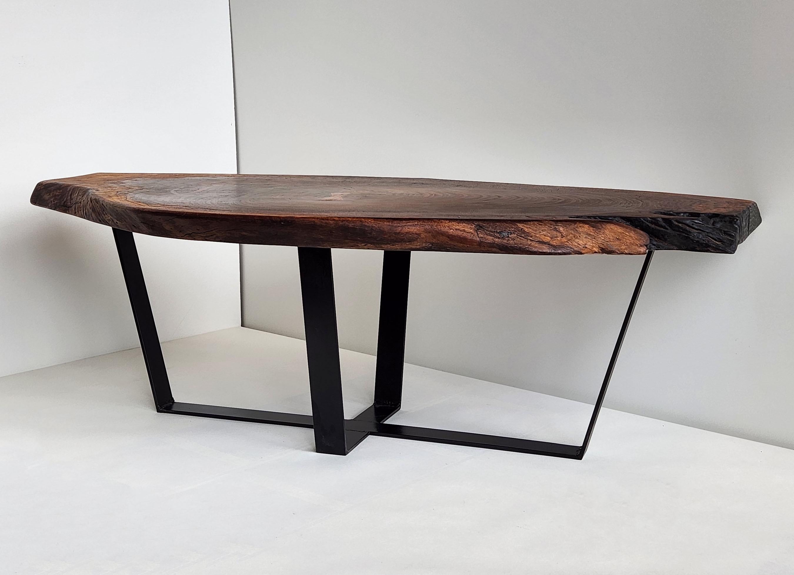 Cette magnifique table basse est fabriquée en bois de noyer noir, qui est sombre, dur, dense et à grain serré. Il est connu pour sa résistance, sa texture et sa couleur. Il se polit jusqu'à obtenir une finition extrêmement lisse. Le bois de noyer