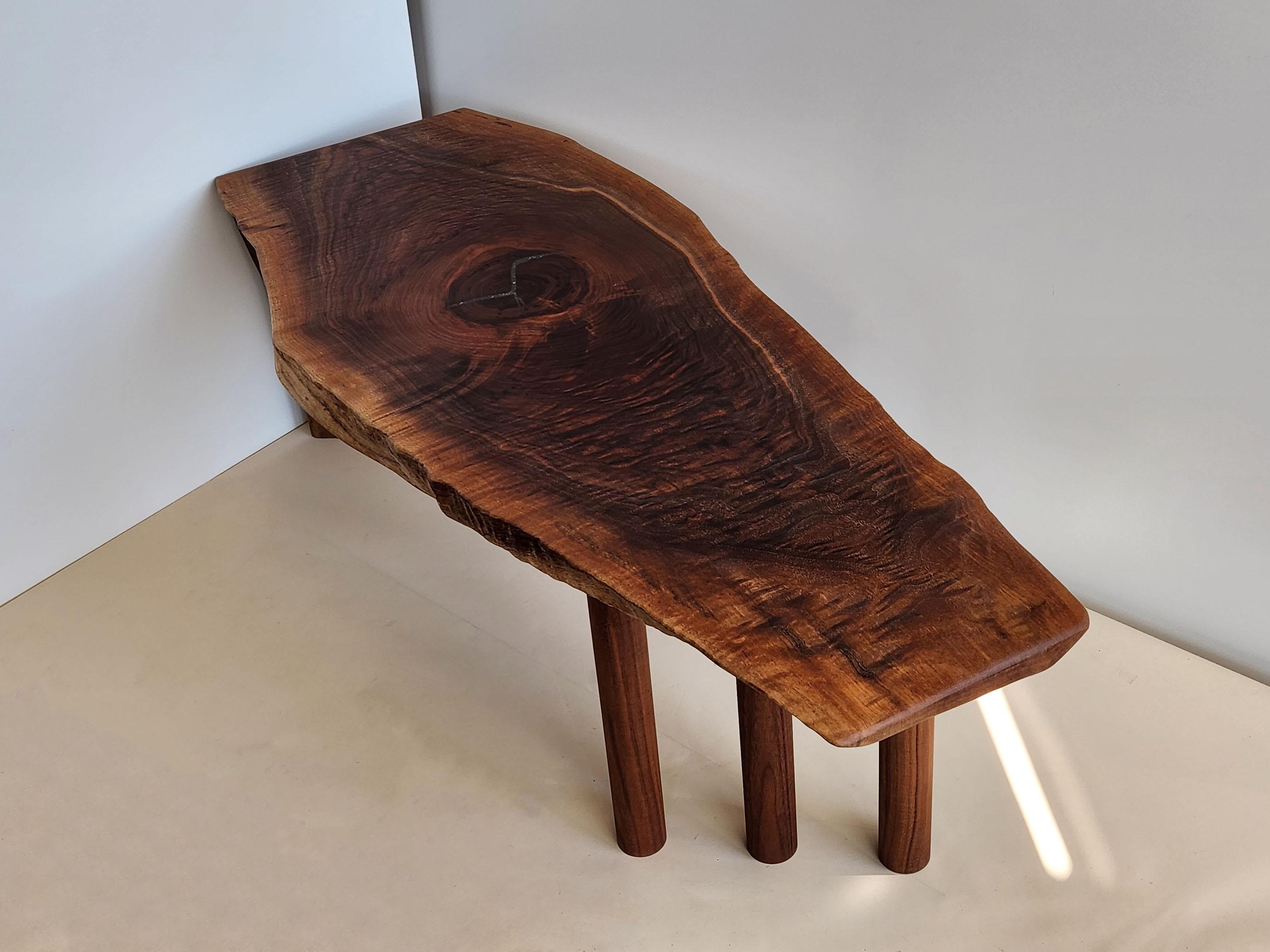 Cette magnifique table basse est fabriquée en bois de noyer noir, qui est sombre, dur, dense et à grain serré. Il est connu pour sa résistance, sa texture et sa couleur. Il se polit jusqu'à obtenir une finition extrêmement lisse. Le bois de noyer