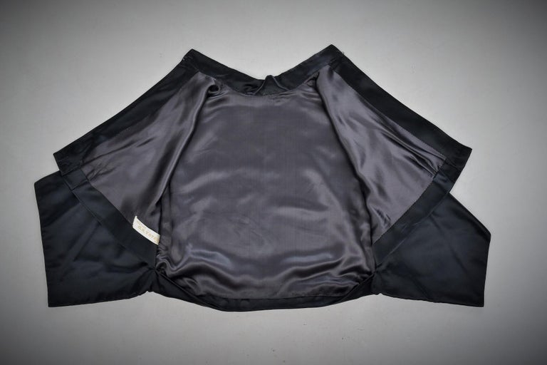 Circa 1958 - 1962

France

Amazing Japanese skirt and bolero set in black waxed satin from the House of M.A Vatan in Dijon dating from the early 1960s. Loose bolero with small officer collar and short sleeves Kimono. Obvious reference to the