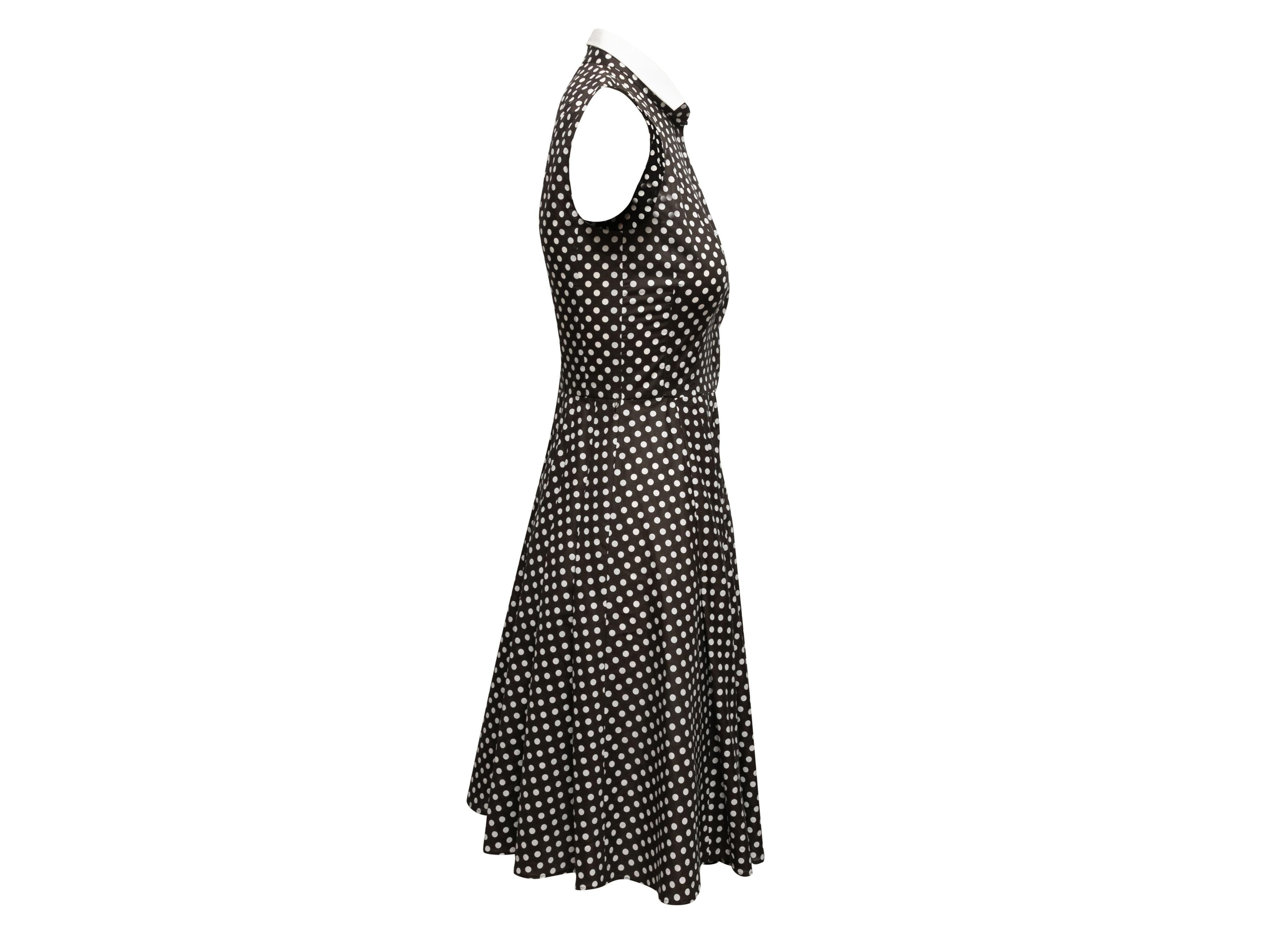 Black and white sleeveless polka dot print A-line dress by Akris. Pointed collar. Button closures at front bodice. 30
