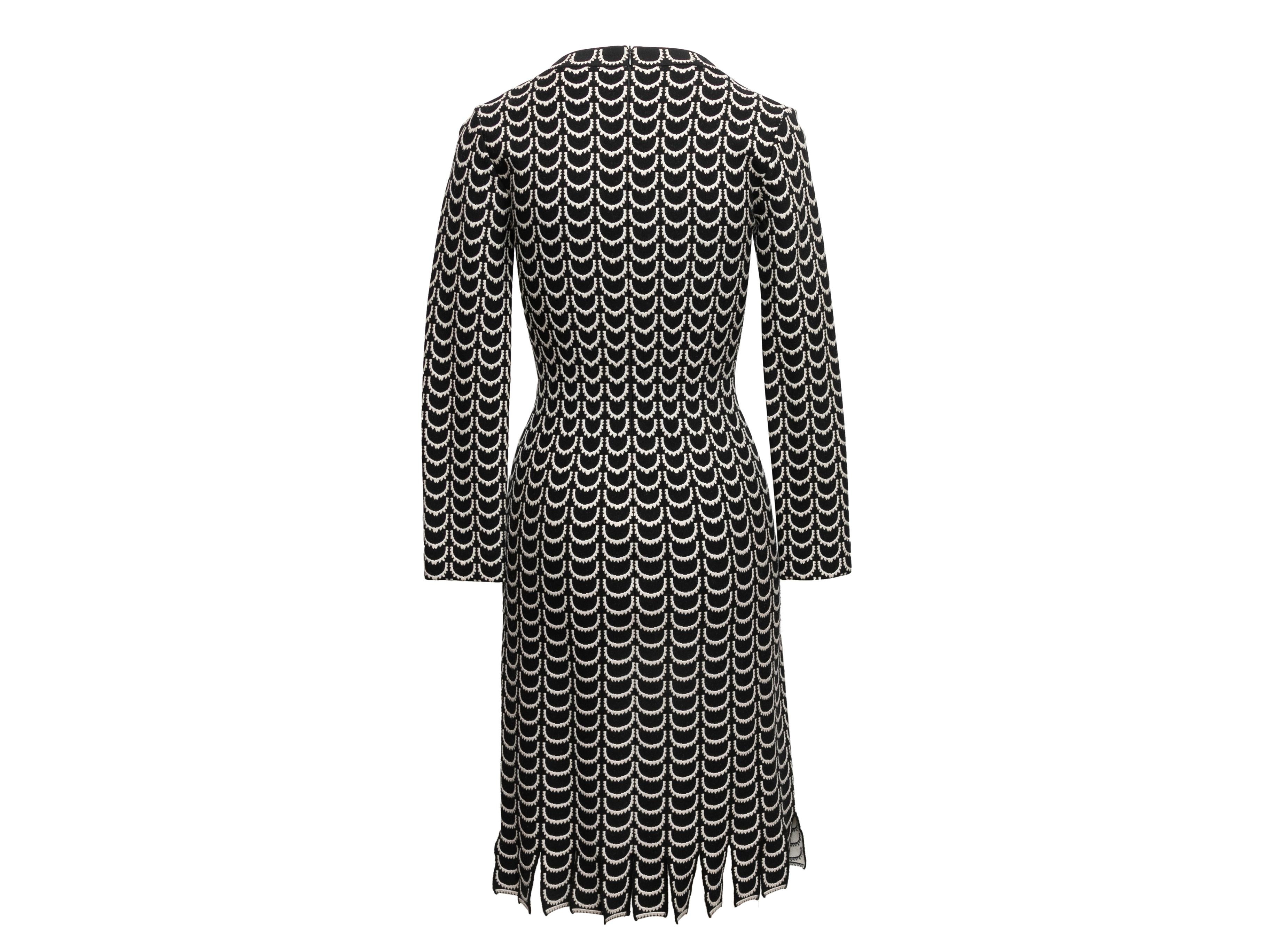 Black and white knit patterned dress by Alaia. V-neck. Long sleeves. Fringe hem. Zip closure at center back. 33