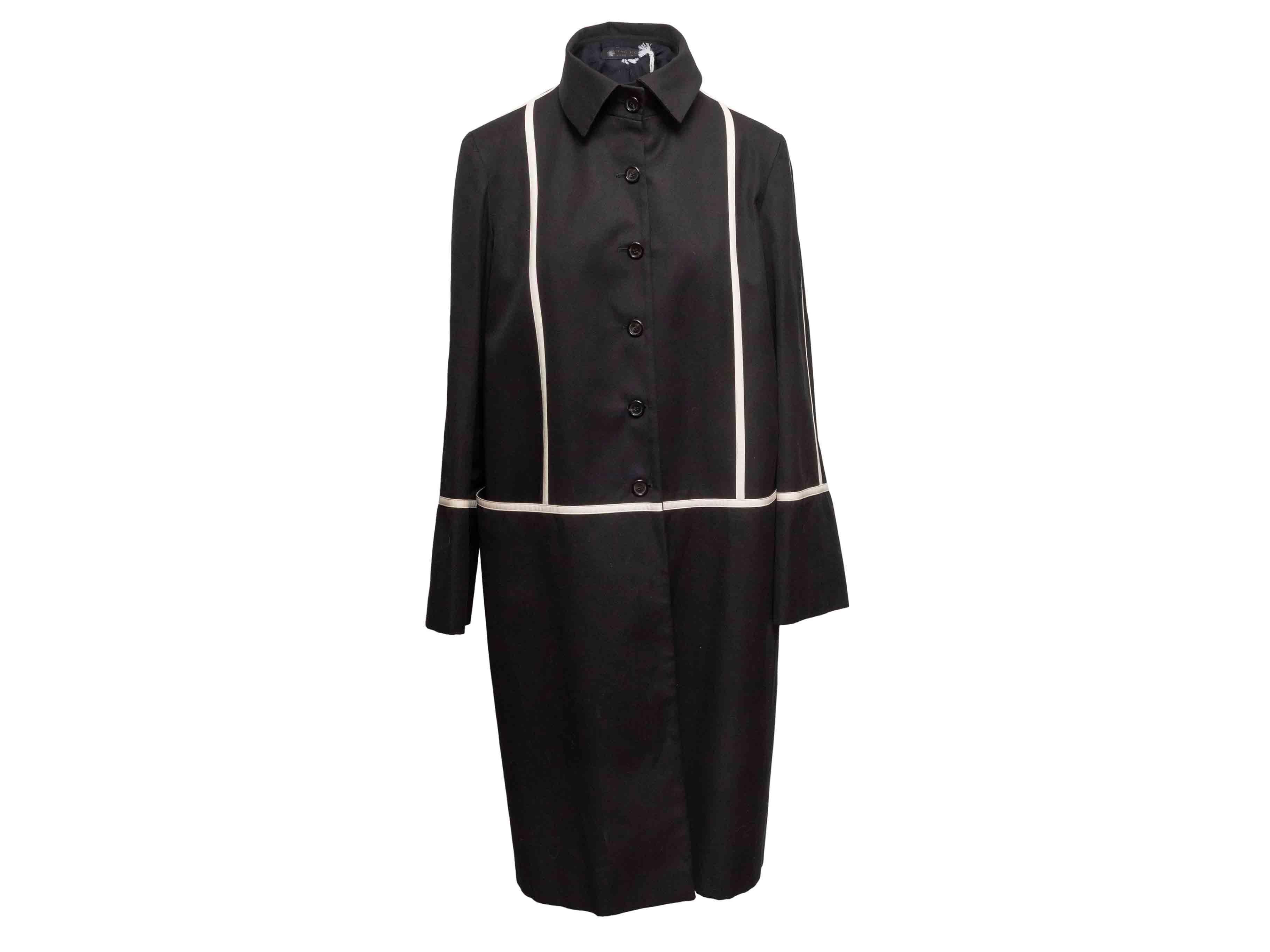 Trench in cotone bianco e nero di Balmain. Rivestimento in pelle su tutta la superficie. Collo a punta. Chiusura con bottoni al centro davanti. Seno 41