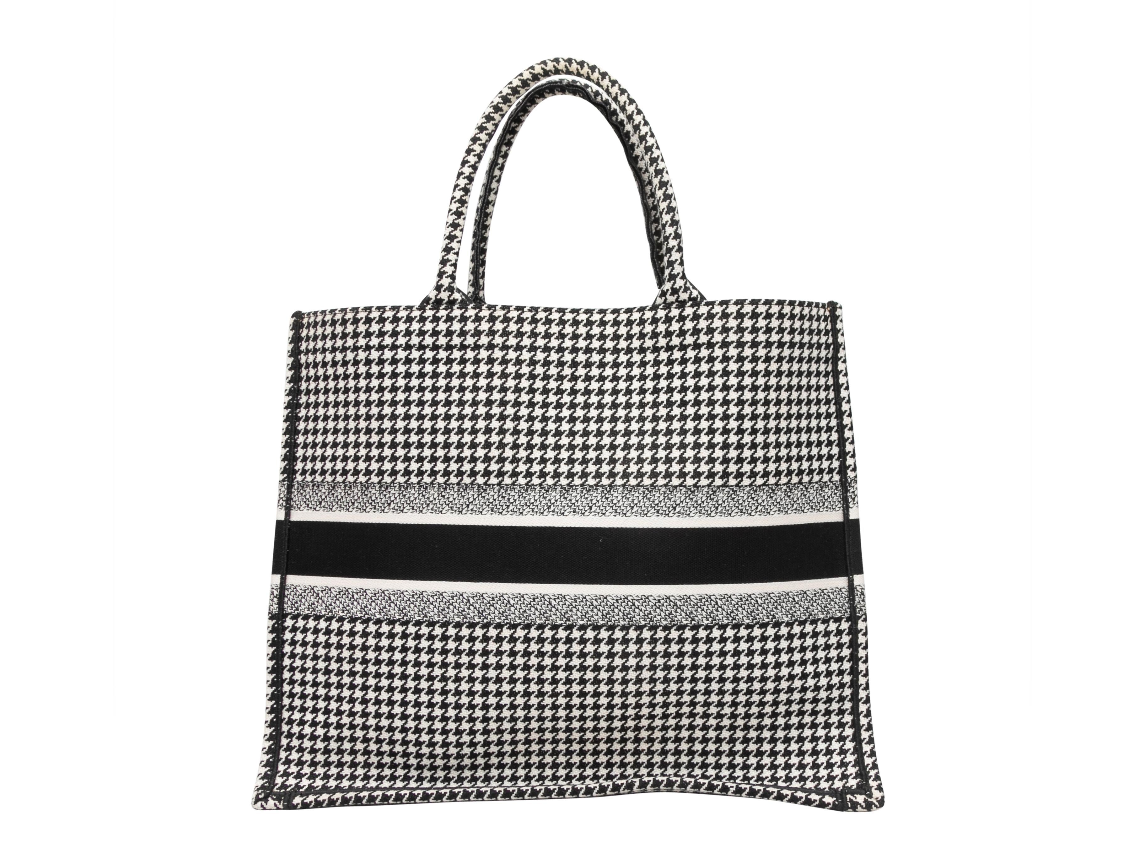 Black & White Christian Dior Medium Houndstooth Book Tote. The Medium Houndstooth Book Tote features a canvas body and dual rolled top handles. 16.5