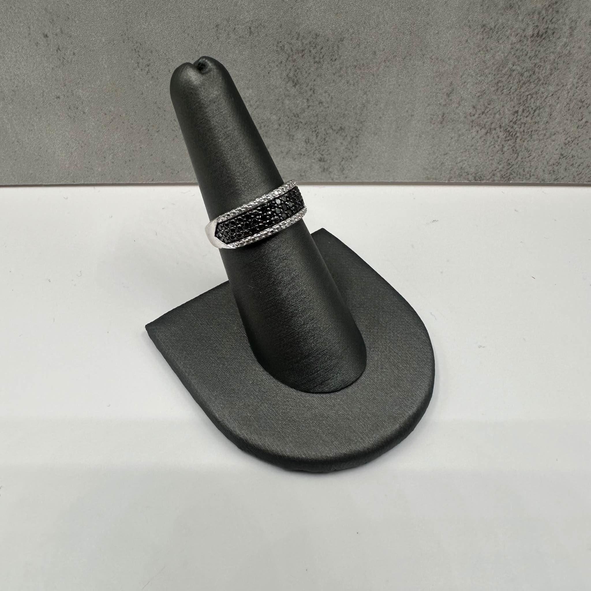 This stunning Black and White Diamond Ring in 14kt white gold features 0.25ctw of round black diamonds, complemented by 0.01ctw of natural HI SI round single-cut diamonds for a striking contrast. Sized at 6.75, it fits comfortably on most average