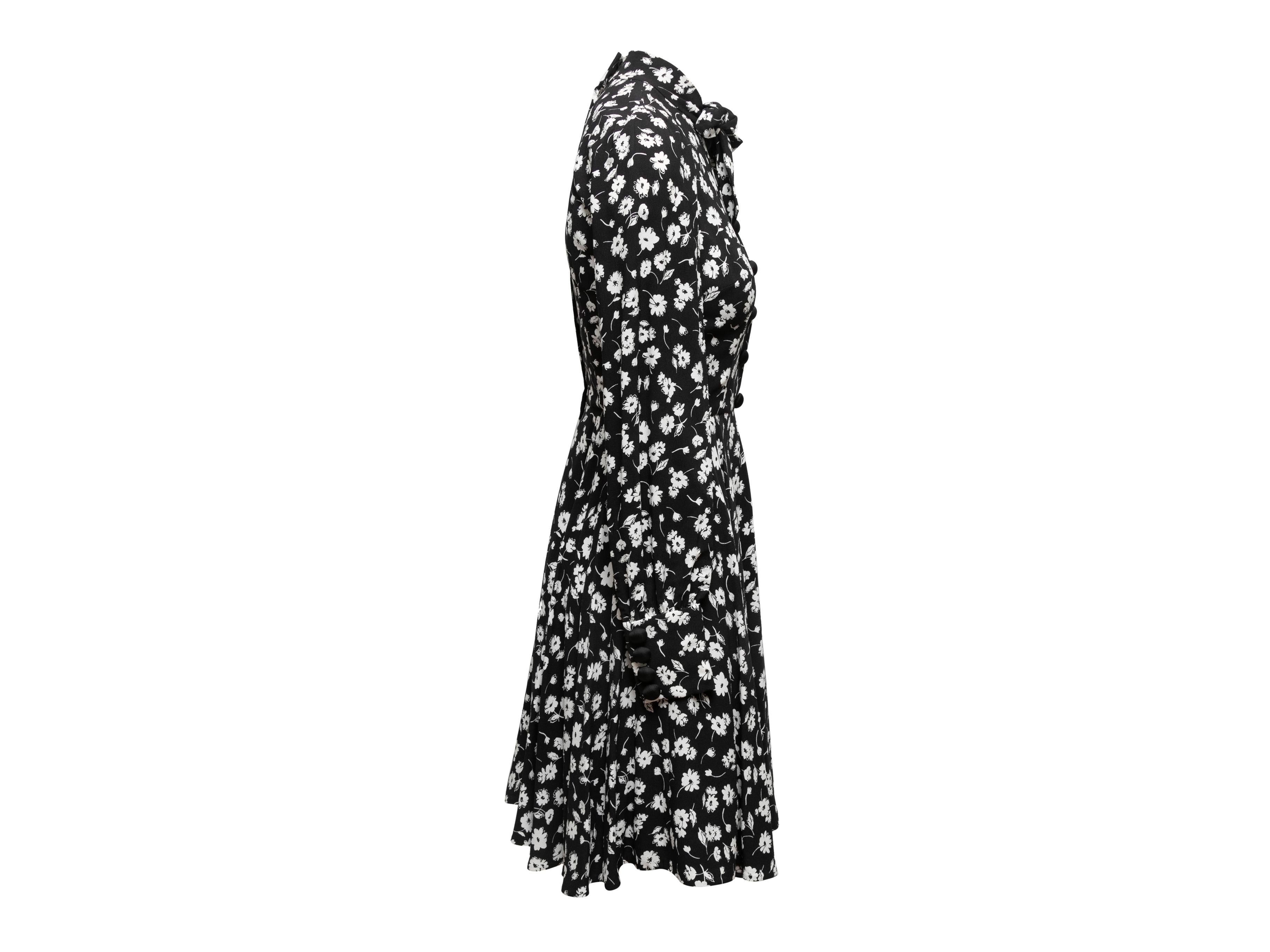 Black and white floral print long sleeve dress by Dolce & Gabbana. Pussy bow at neck. Buttons at front bodice. Zip closure at center back. Designer size 38. 33