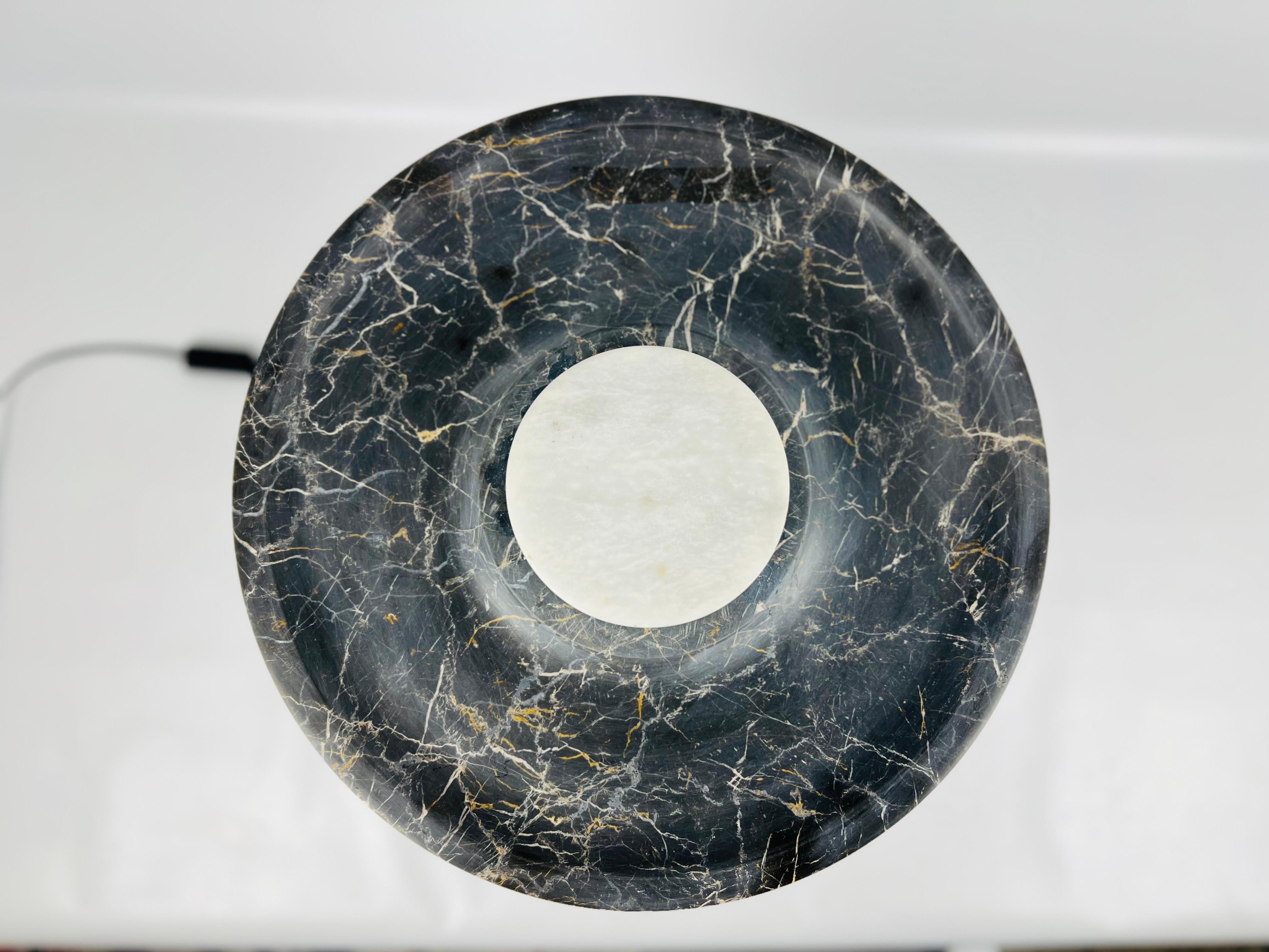 Our black and white marble halo table lamp is a stylish lighting fixture that is perfect for adding a touch of sophistication to any room in your home. The lamp features a cylindrical stem base made from high-quality marble stone, which provides a