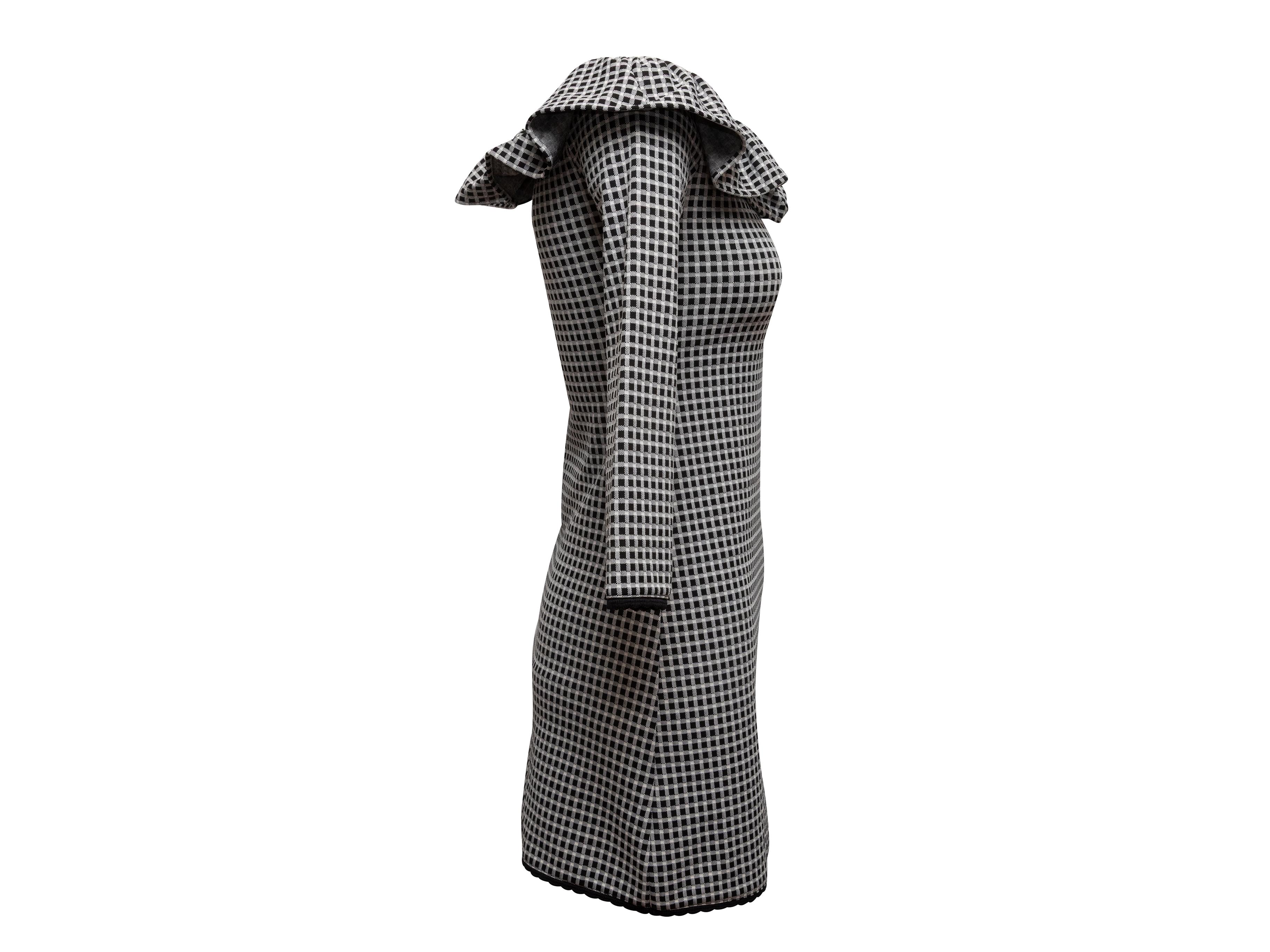 Black and white gingham off-the-shoulder mini dress by Miu Miu. Ruffle trim at neckline. Long sleeves. 30