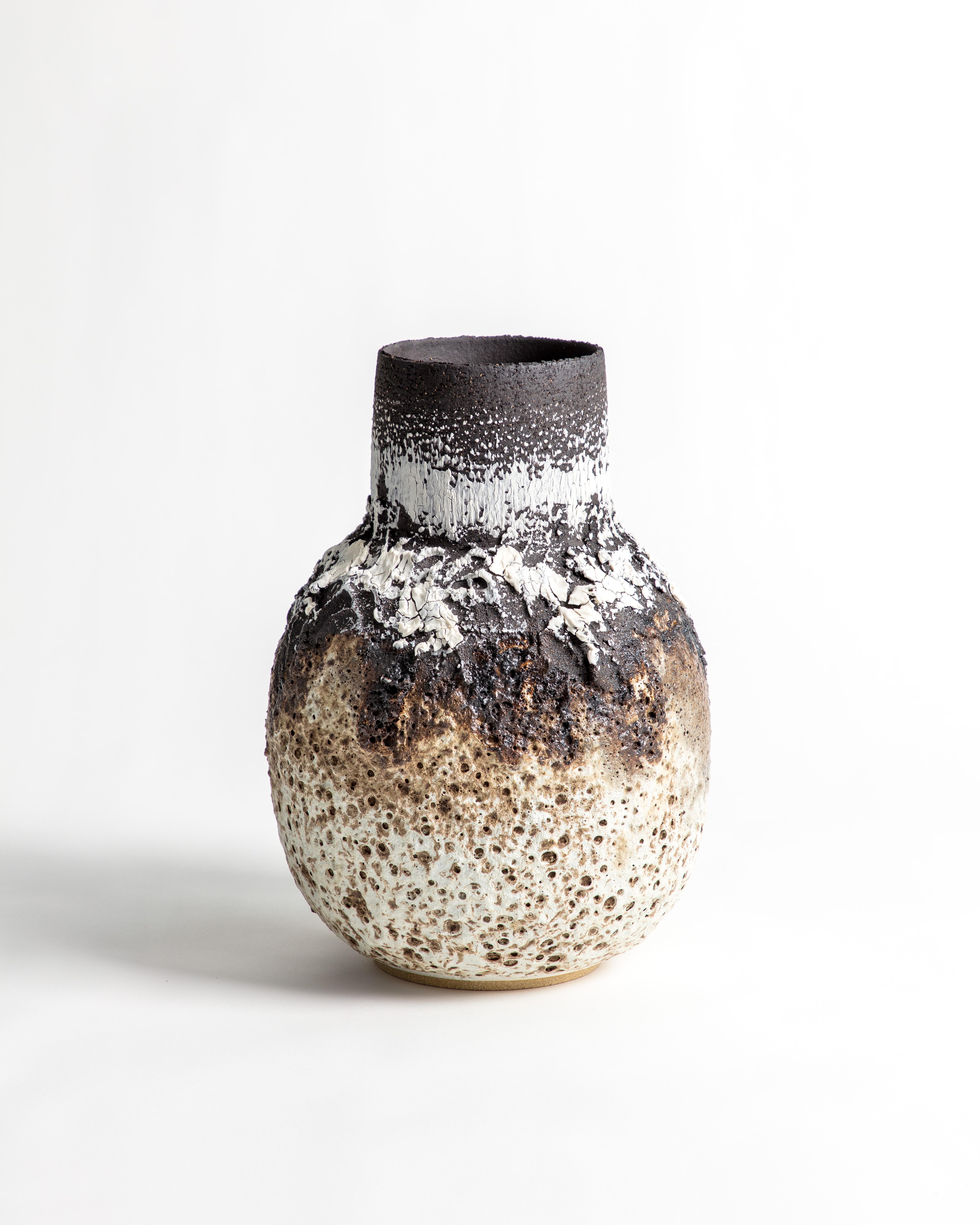 Vaso vulcanico di grandi dimensioni con smalto nero, bianco e marrone e marcature. Vaso dal collo largo e dalla forma panciuta. Realizzato in gres e porcellana di colore nero.

L'ispirazione per il pezzo viene dall'argilla stessa e dalle relazioni