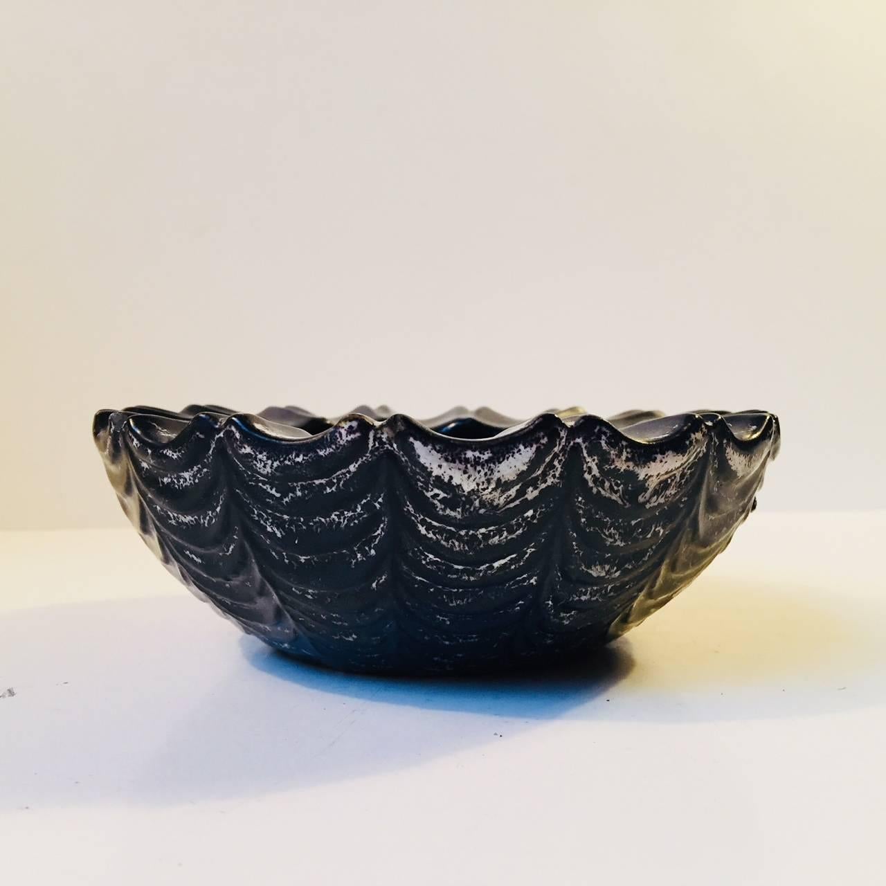This fluted bowl features the signature coal based glaze by Hammershøi, and was produced circa 1920 by HAK/Kähler in Denmark. Fully stamped to the base.