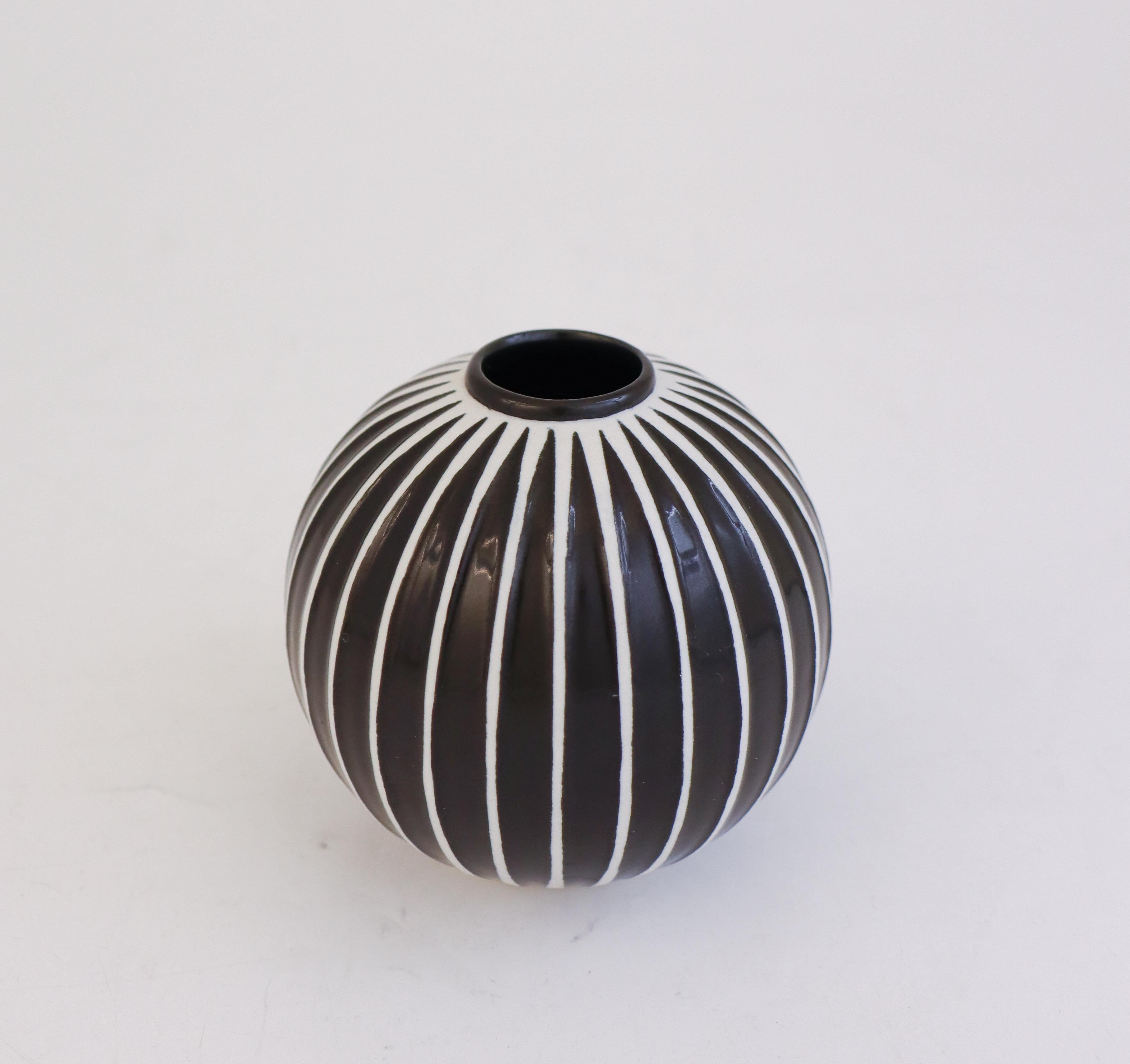 Un delizioso vaso sferico in porcellana disegnato da Stig Lindberg a Gustavsberg. Il diametro è di 9,5 cm. È in ottime condizioni ed è uno dei design più iconici degli anni '50. 

La serie Domino fu creata da Stig Lindberg nel 1954 in occasione