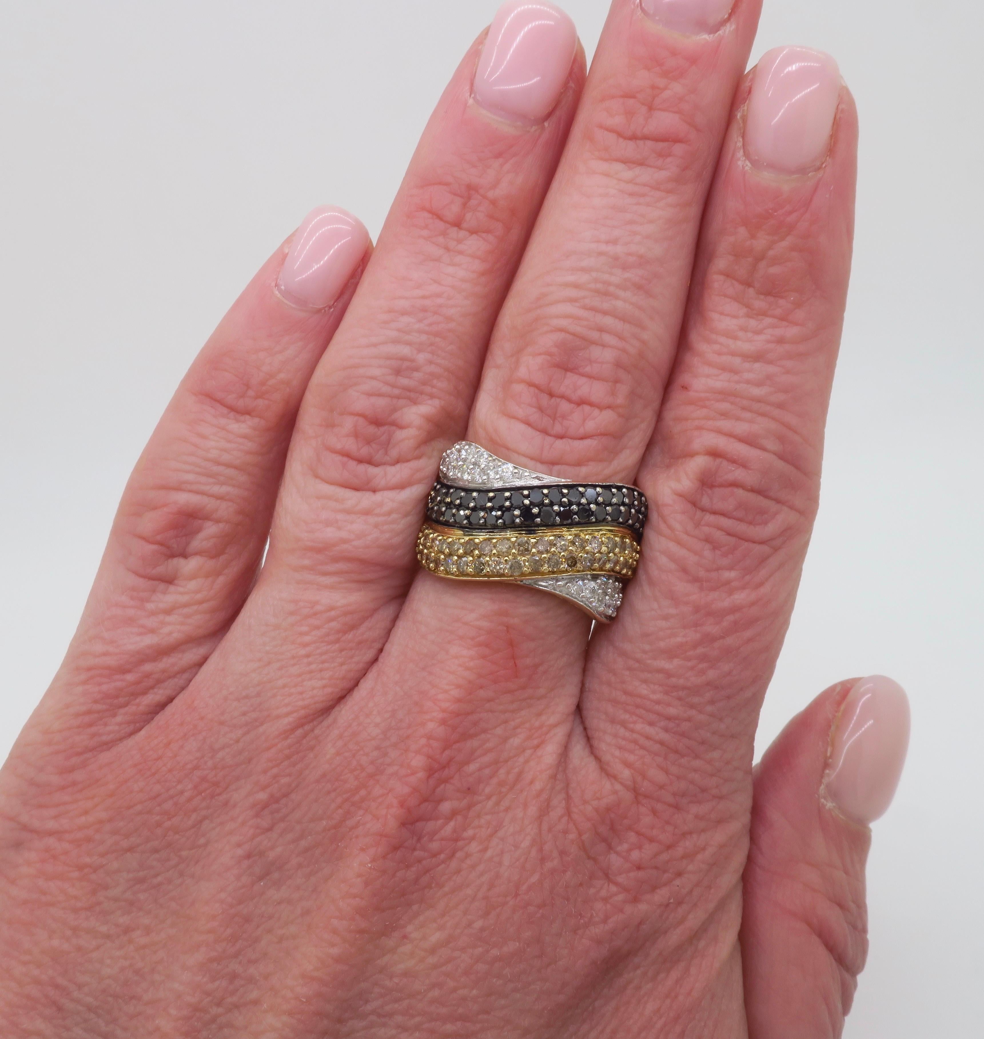 Black, white, and yellow diamond crossover ring crafted in 14k yellow gold.

Diamond Carat Weight: 1.75ctw
Diamond Cut: Round Brilliant cut 
Color: G-H, Champagne, Black
Clarity: SI1-I1
Metal: 14k Yellow Gold 
Stamped: 