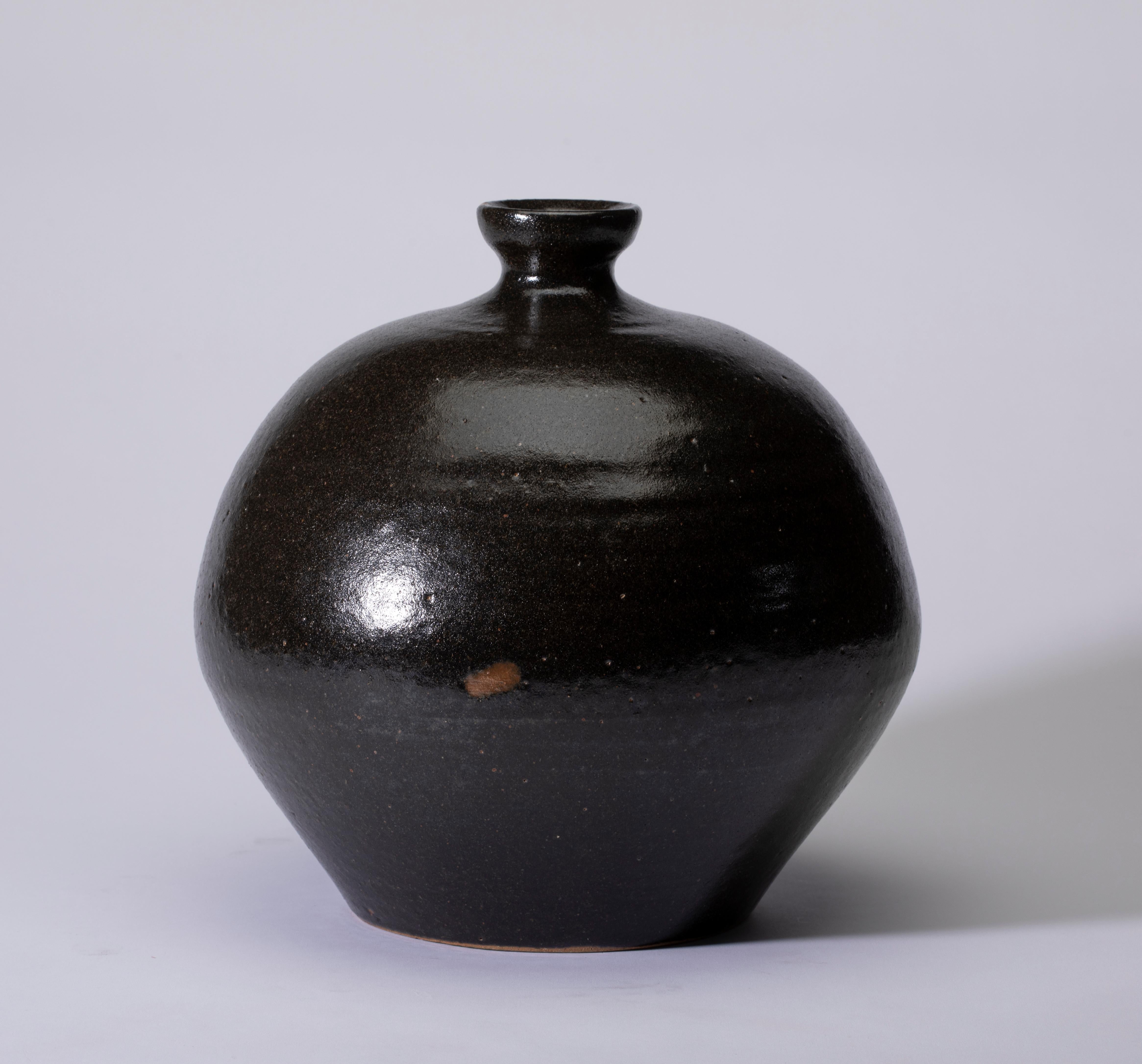 Vase en terre cuite de Mashiko, noir avec des nuances brunes 
Vase en terre cuite de Mashiko à glaçure noire avec nuances brunes
L'argile de la région est une forme pure d'argile riche en acide silicique et en fer qui produit une couleur profonde,
