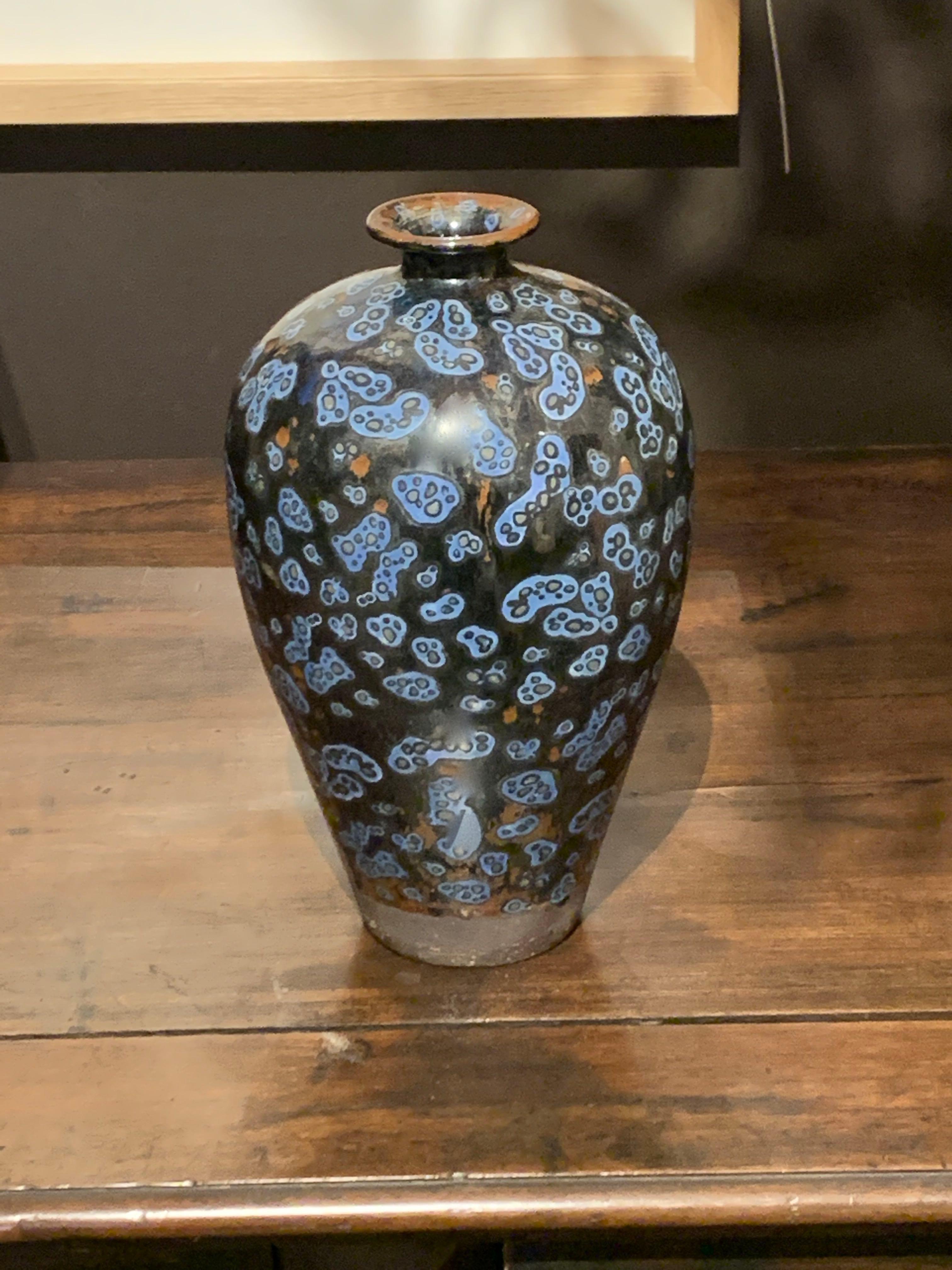 Contemporary Chinese ceramic vase black ground with royal blue squiggle decorative design. Random pops of orange color give the vase a vintage appearance. Natural taupe color band at bottom of vase.
Classic shape.
Two are available and sold