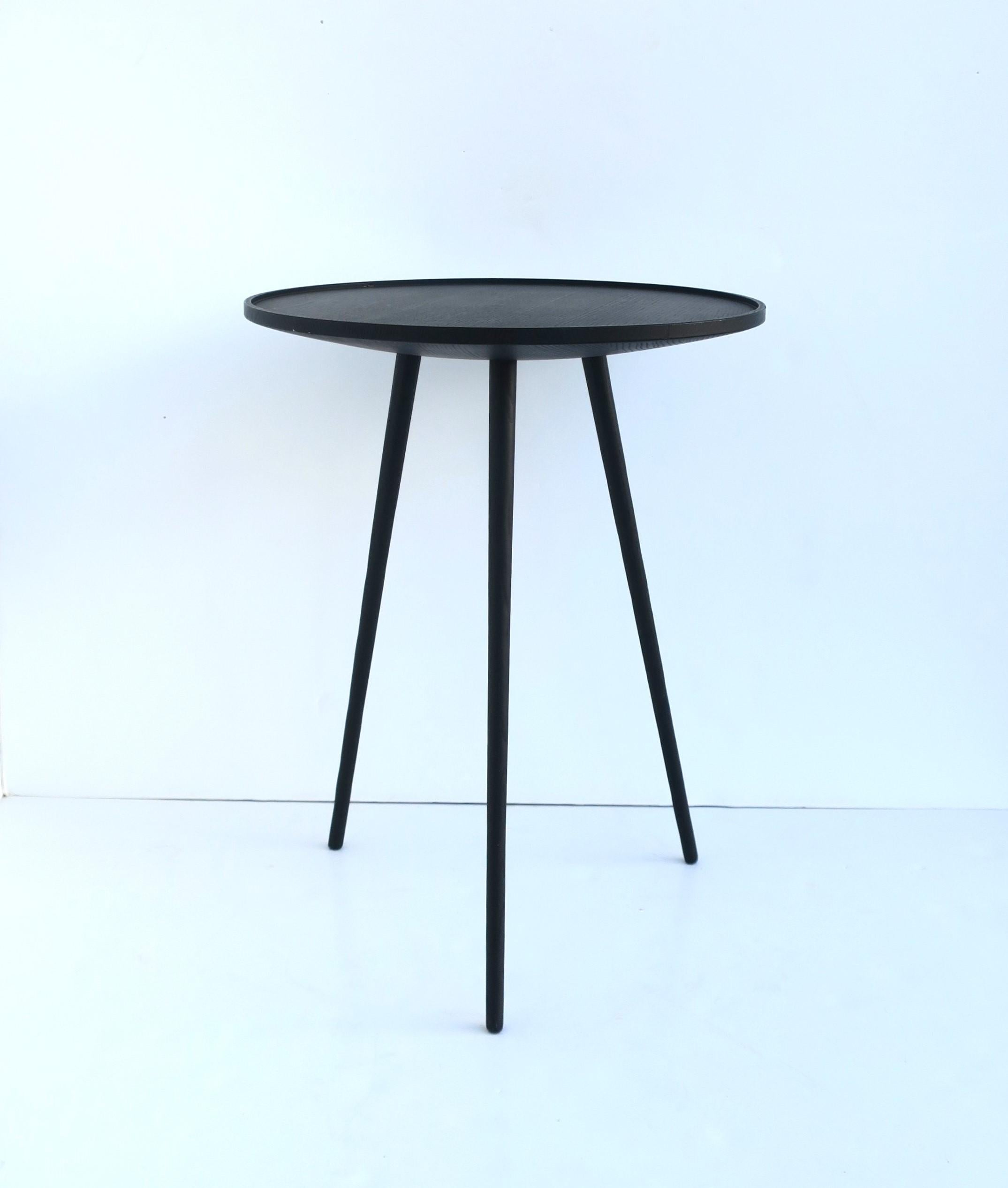 Ein schwarzer Beistell- oder Getränketisch aus Holz mit runder Platte und Dreibeinfuß, im minimalistischen oder modernen Designstil, circa Anfang des 21. Jahrhunderts. Abmessungen: 15,75