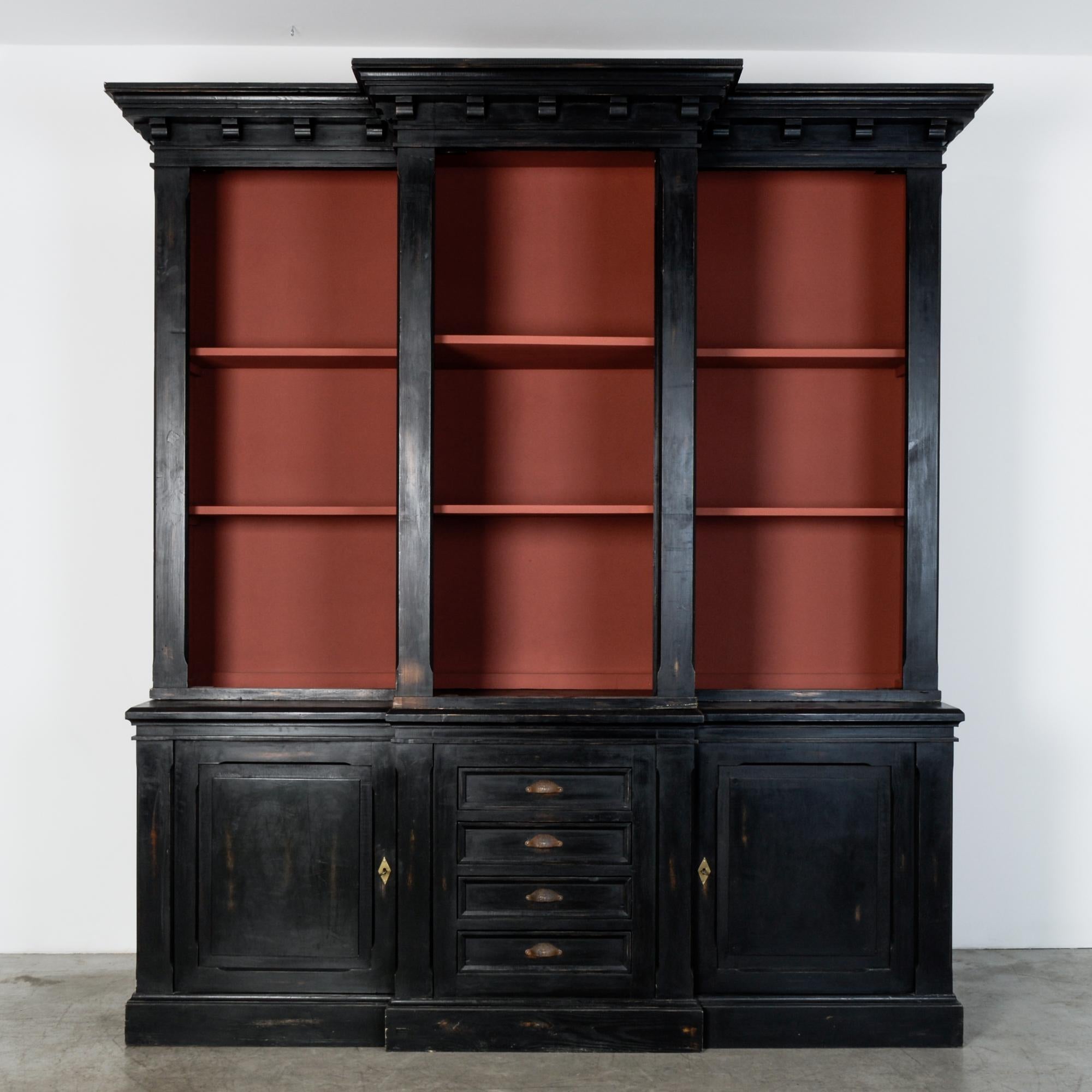 A modern re-creation based on neoclassic style, this black painted cabinet features a two-door base with 4-drawer chest, supporting a tall upper shelving unit, painted in dramatic color. Recessed panel construction and well proportioned moulding