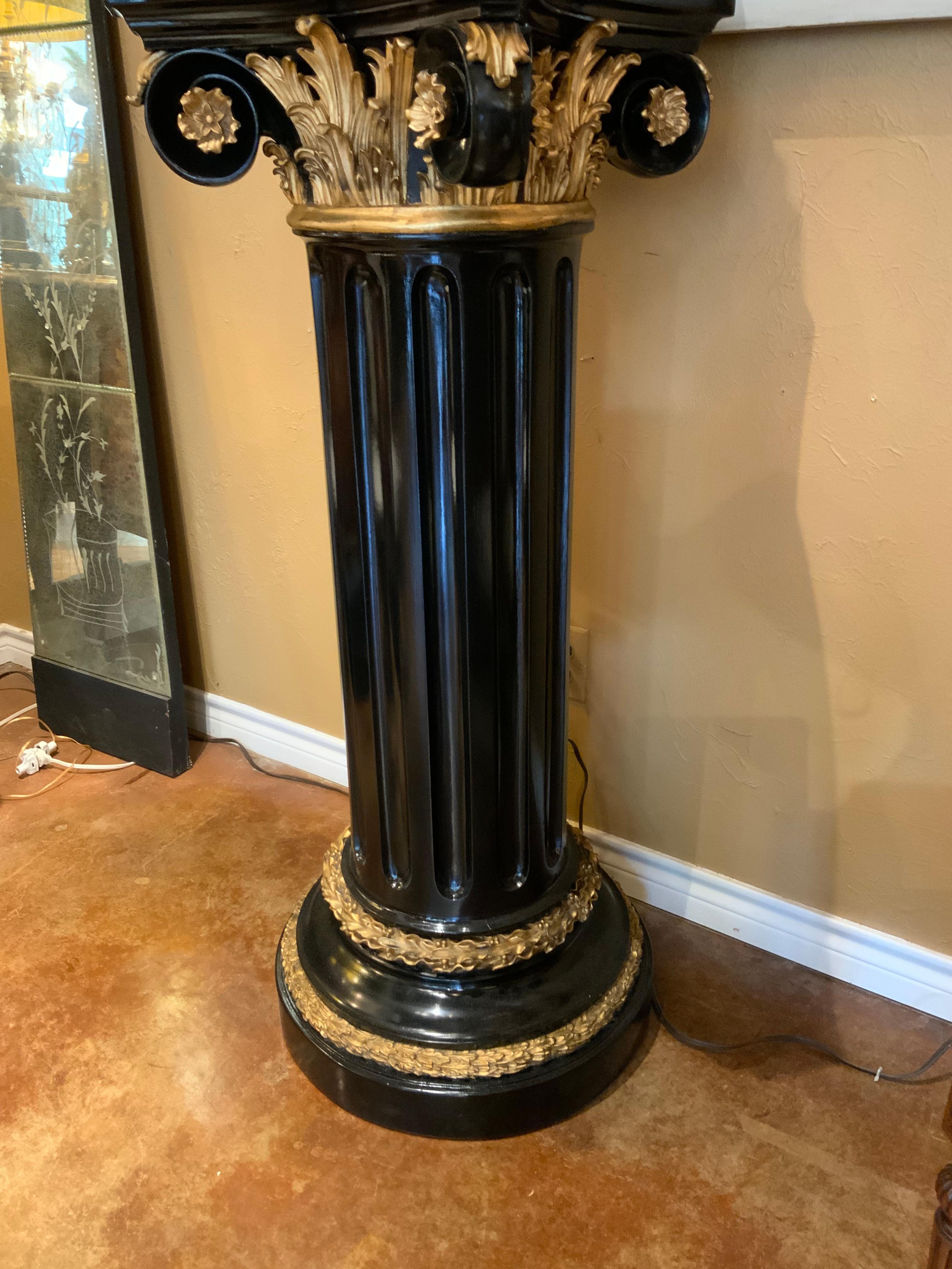Polychromed pedestal in black with gilt accents on the upper supports and
On the base.