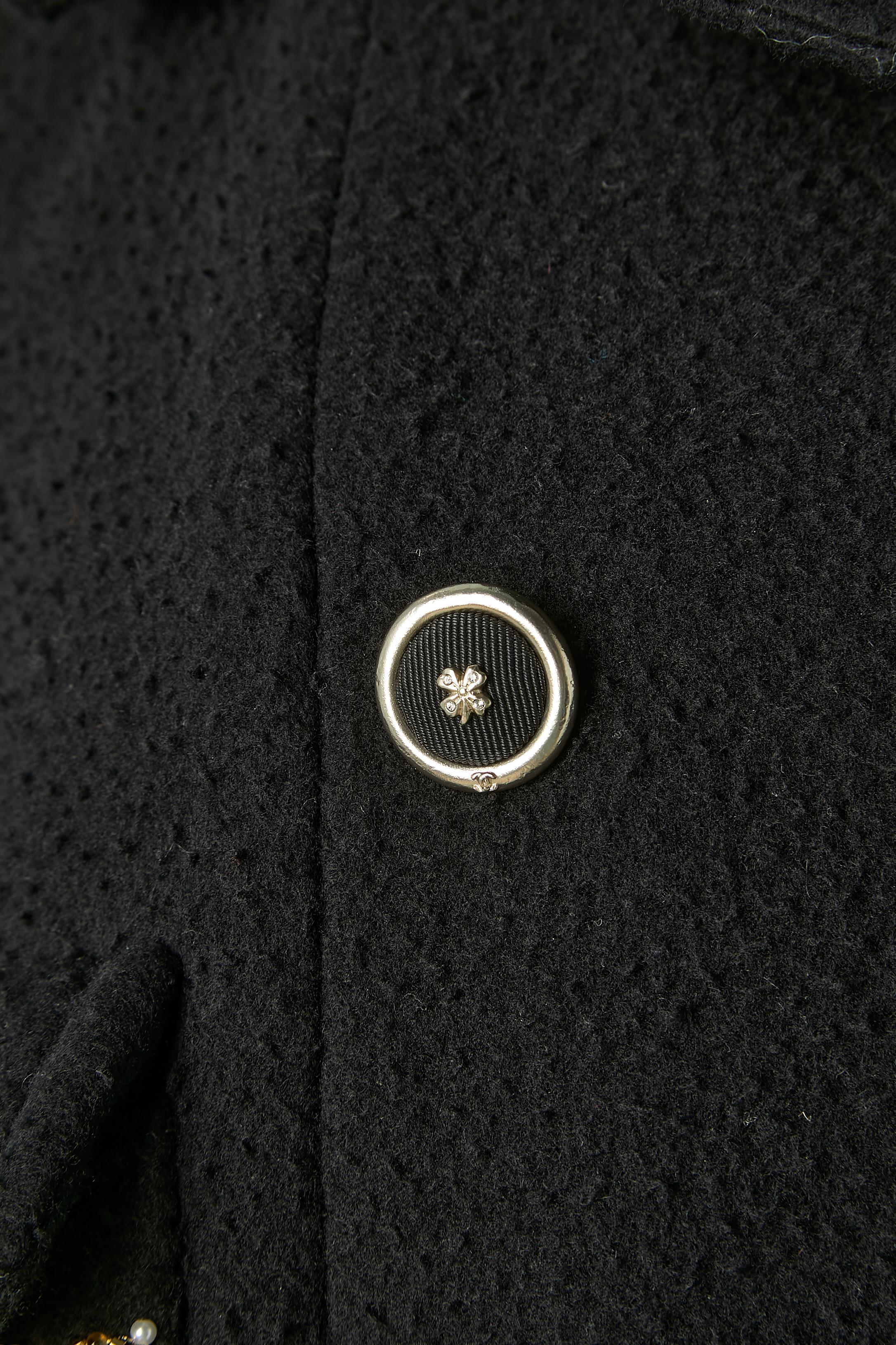 Black wool and cashmere double-breasted coat with embroideries ( rhinestone, gold leather and beads) on pockets. Main fabric composition: 50% wool, 30% cashmere, 20% polyamide. Silk lining. Branded buttons with clover on. 
Chanel SAMPLE / Collection