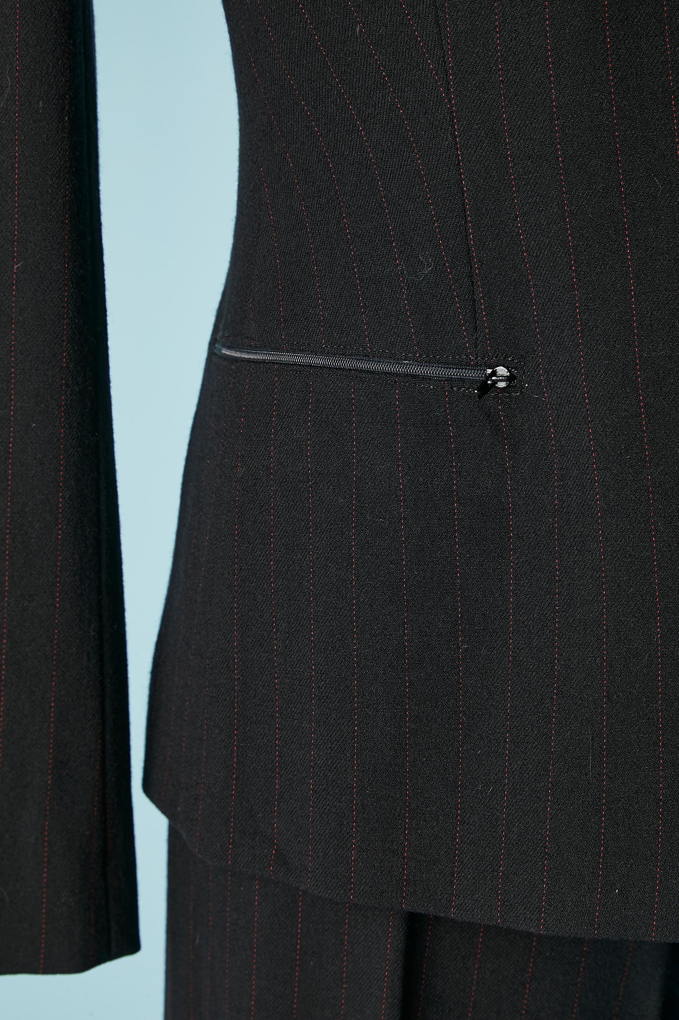 Black wool and red pin-stripes trouser-suit and fur vest. Main fabric composition: 95% wool, 4% elastane, 1% polyester. Lining: 62% rayon, 38% polyester. The fur is razor cut in horizontal stripes.
Zip closure in the middle front and pockets. Double