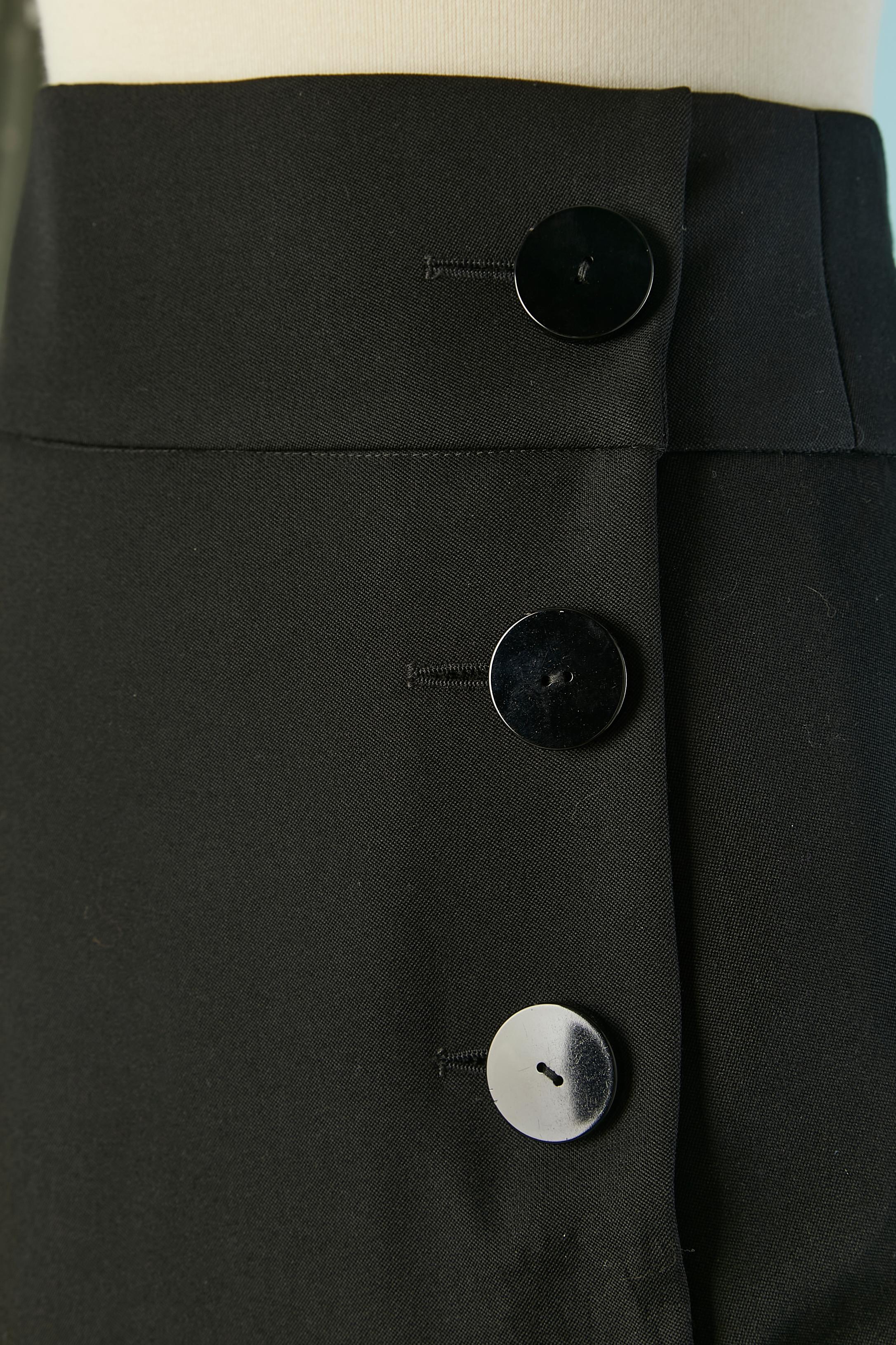 Jupe à volants en laine et soie noire (60% acétate, 40% soie) Doublure : 55% acétate, 45% rayonne. 
Fermeture par bouton et boutonnière sur le côté du devant + un crochet et un œillet. Fendre le milieu du front . 
TAILLE 42 (Fr) L 