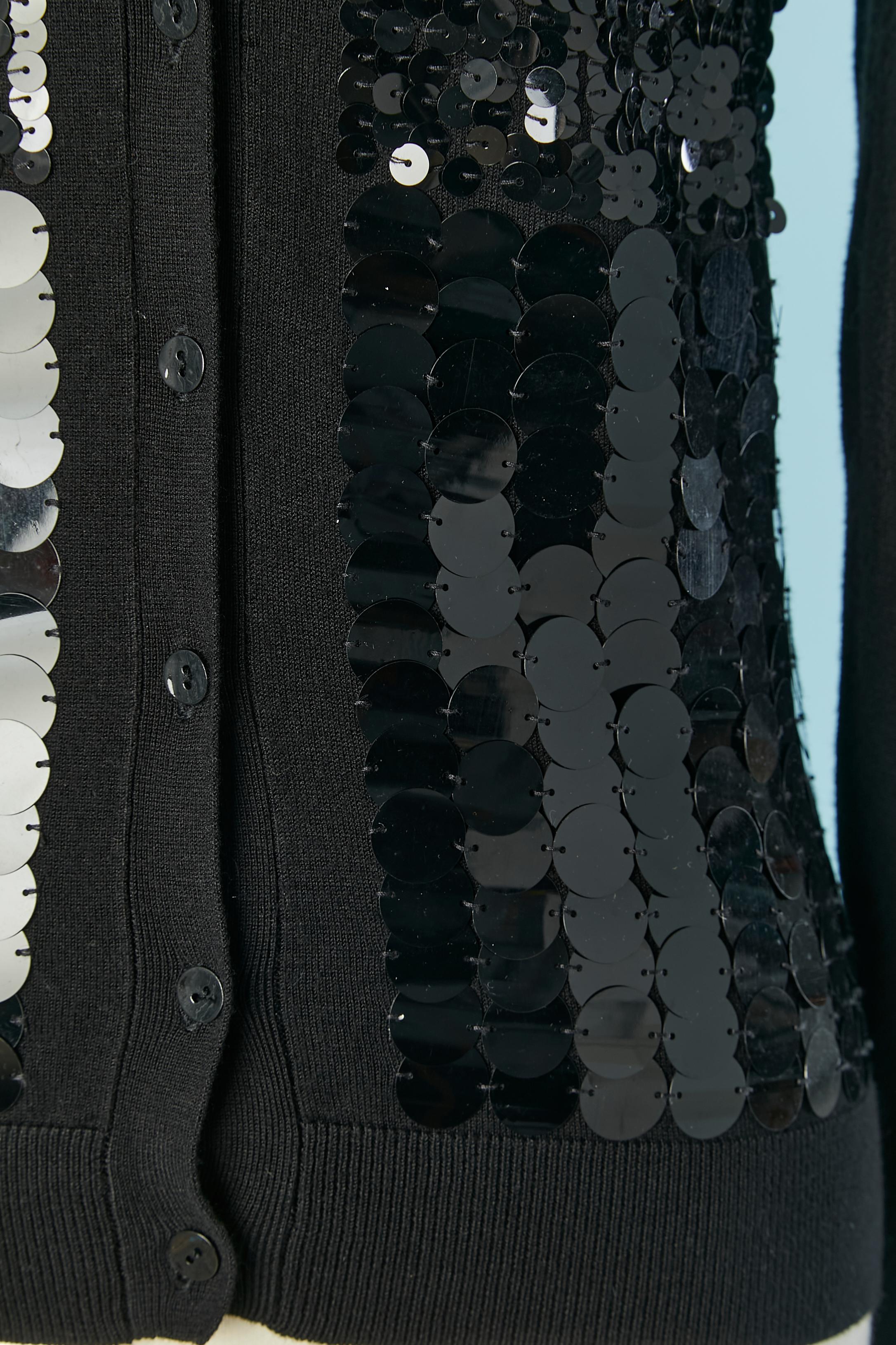 Chaqueta de punto de lana negra con lentejuelas negras (2 tamaños diferentes de lentejuelas) Sin etiqueta de composición de punto, pero probablemente de lana. 
Cierre de botón y ojal en el centro delantero. 
TALLA 36 / S / 6 (US) 