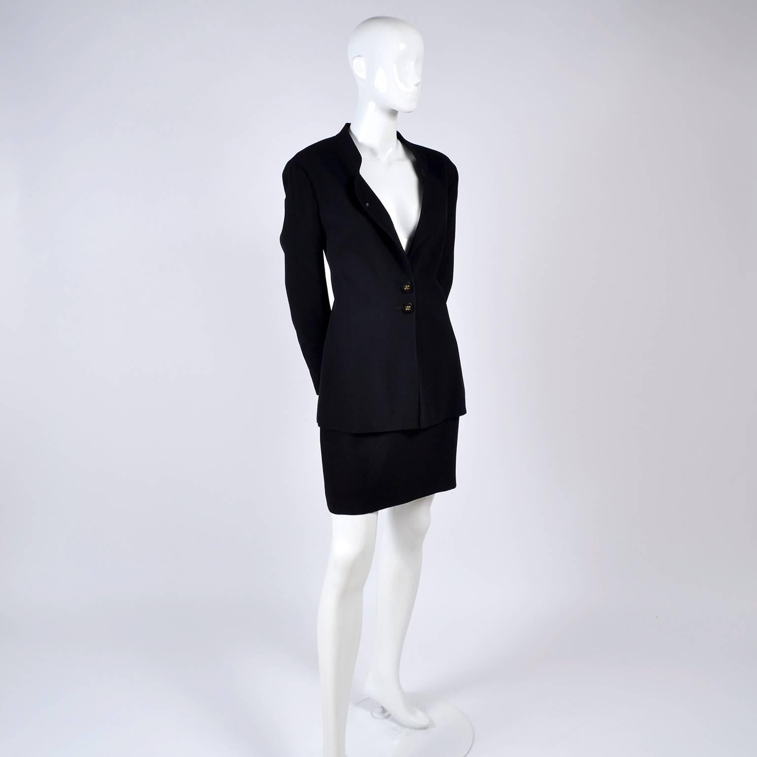 This is a classic vintage black wool Chanel suit with a blazer and skirt. Both pieces are lined in silk. The skirt has a back zipper and the same style of button as the jacket.  The jacket has 2 front black buttons with gold cc logo and a hidden