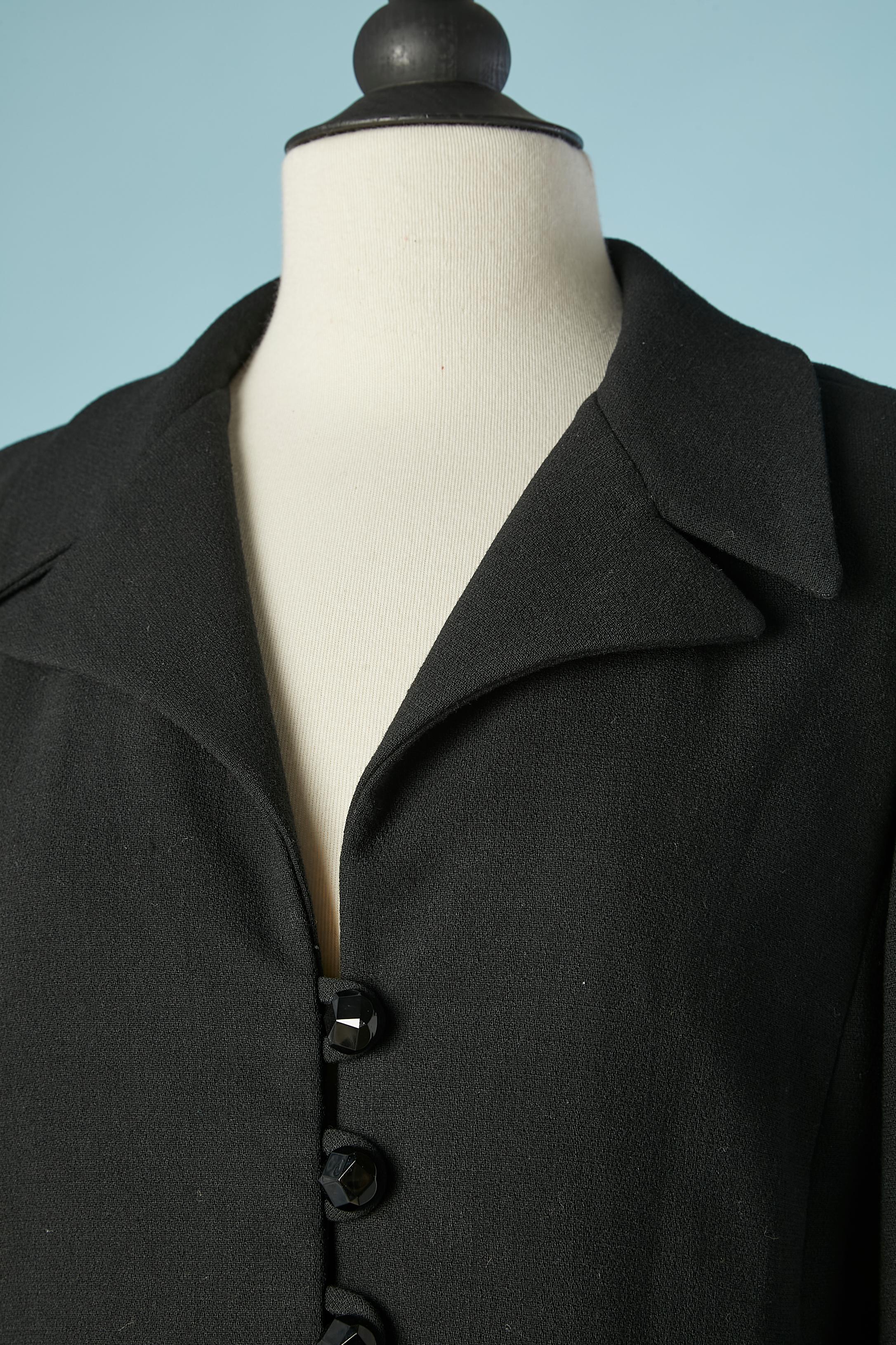 Black wool crepe skit-suit with black buttons .Rayon lining.  Fake pockets. 
SIZE M