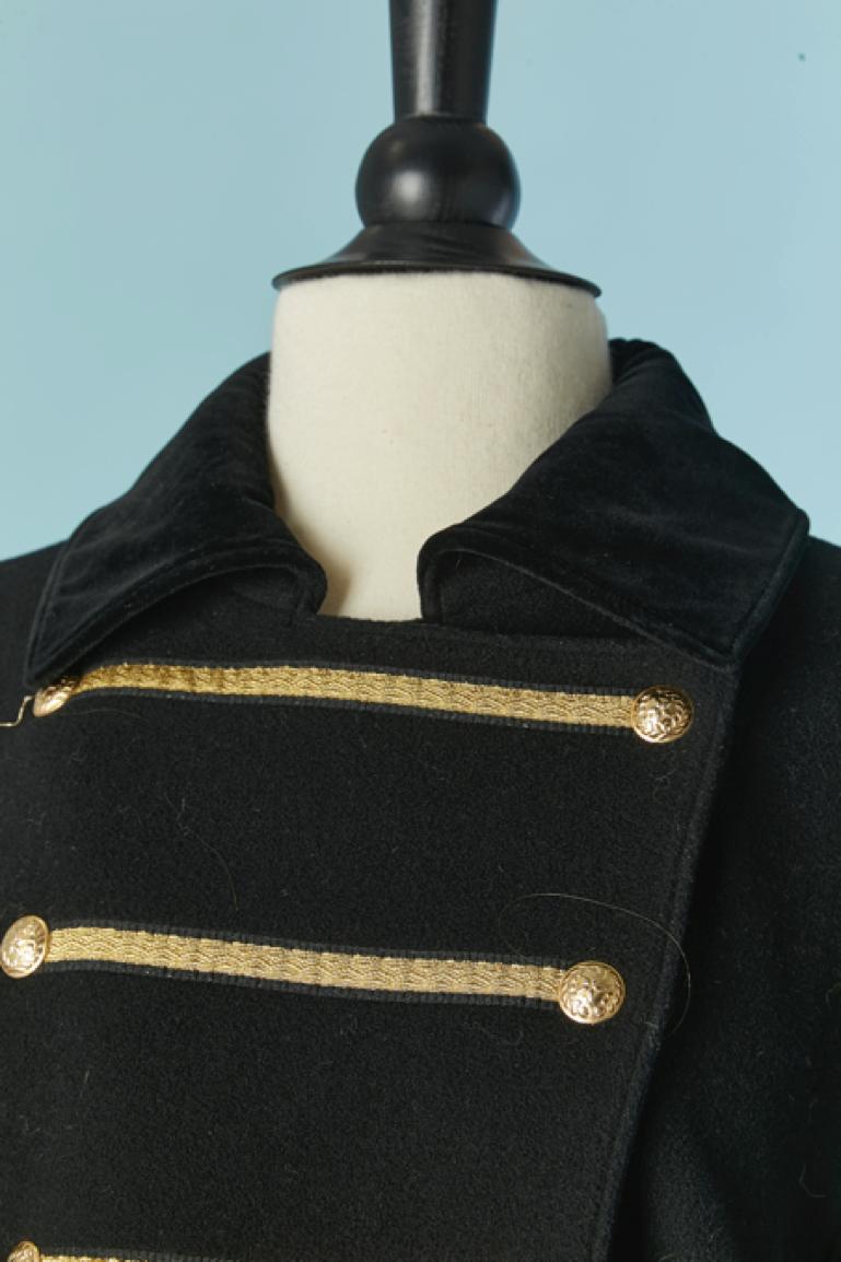 Black wool double-breasted coat with gold passementerie. The fabric composition has been cut but there is probably a bit of cachemire mixed with the wool. Shoulder pad. Snap closure on the front . Pockets on both side. 
SIZE 42 (Fr) L 