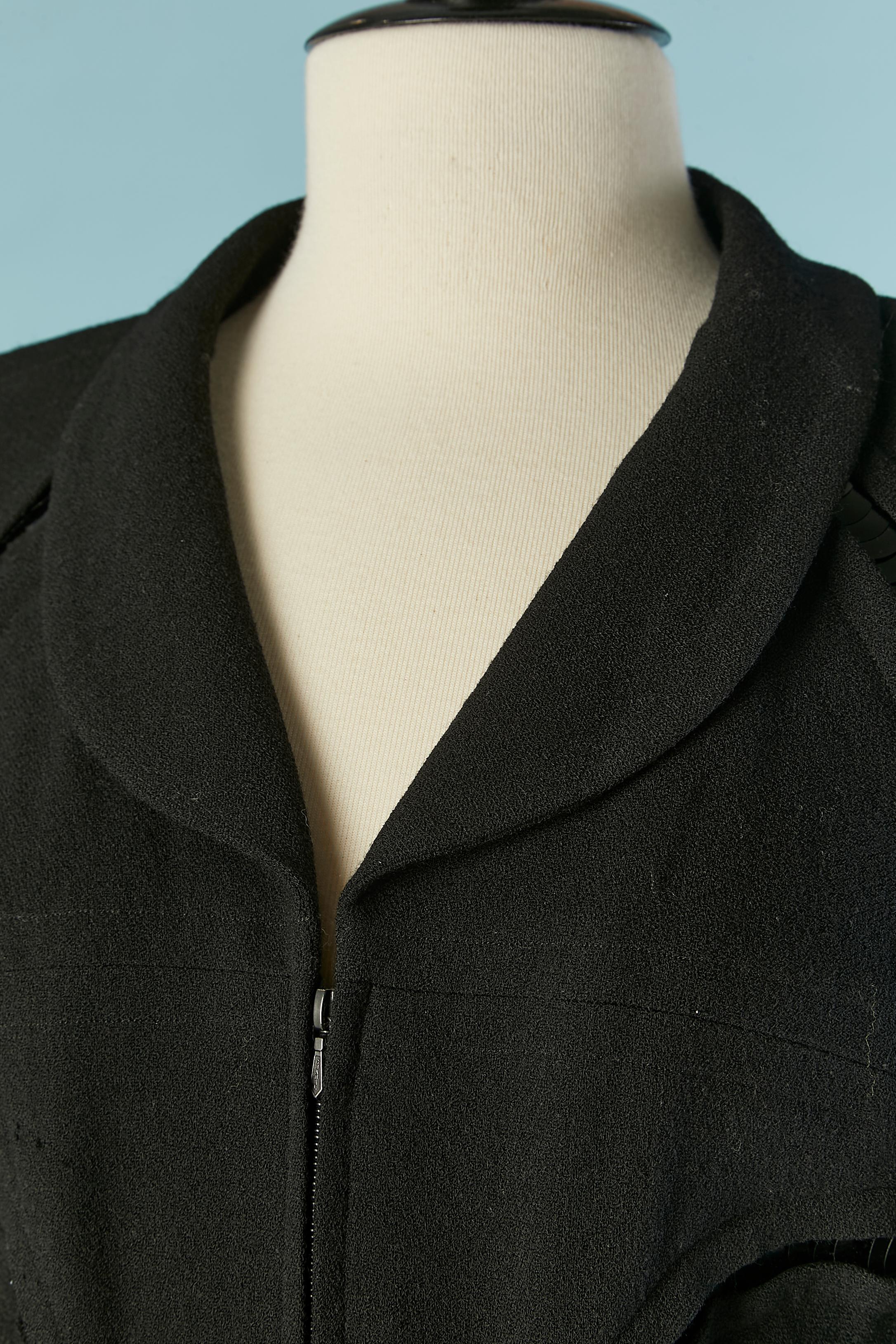 Veste en laine noire avec paillettes noires à l'intérieur de l'échancrure. 
Composition de la doublure : 86% soie, 14% élasthanne. Manches raglan. Chaîne à l'intérieur sur le bord inférieur. Fermeture à glissière cachée sur le milieu du devant avec