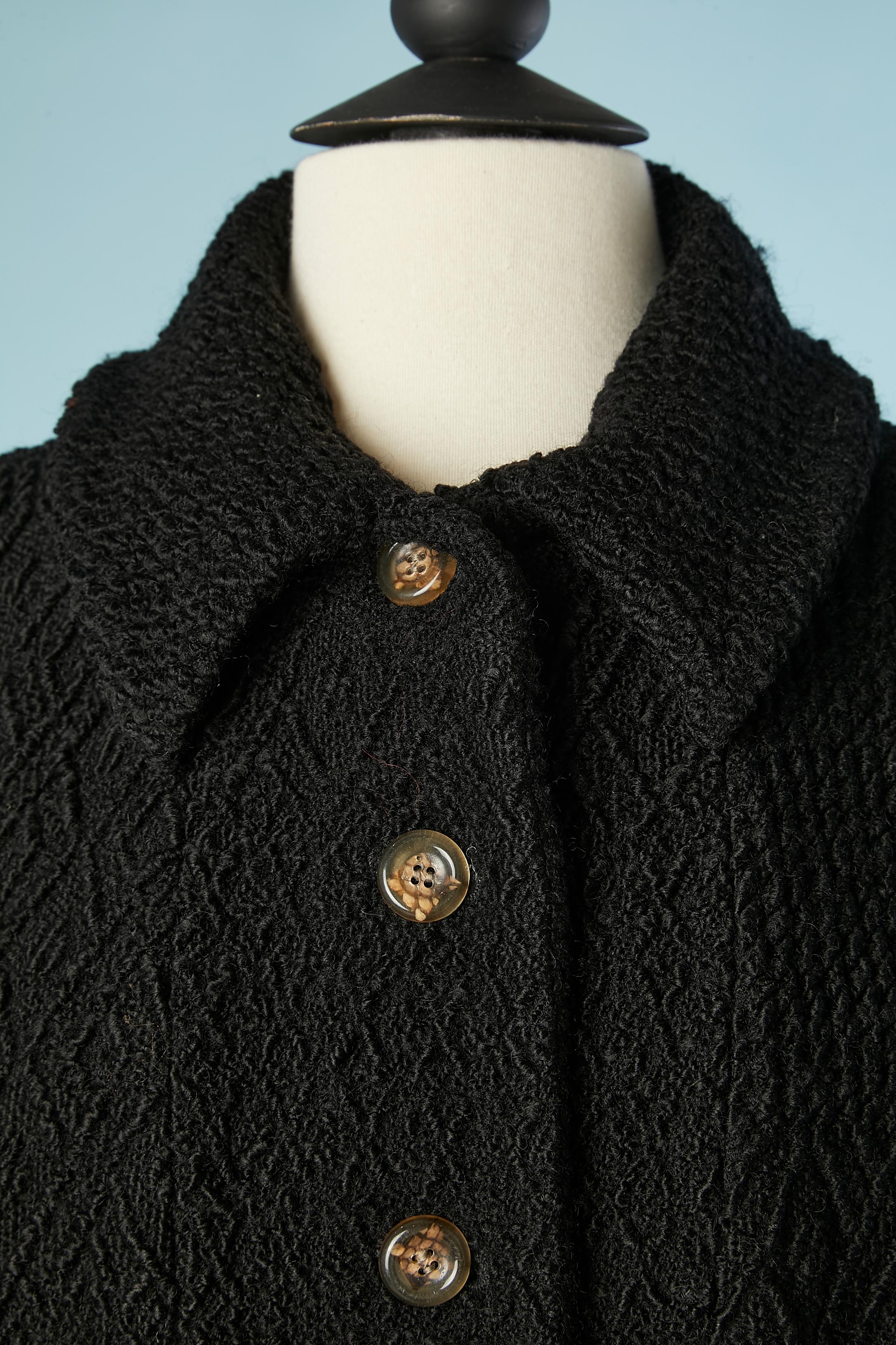 Manteau en jacquard de laine noire avec doublure imprimée rose . Impossible de lire la composition du tissu mais c'est de la laine probablement mélangée à de la soie et du nylon. 
TAILLE XXL