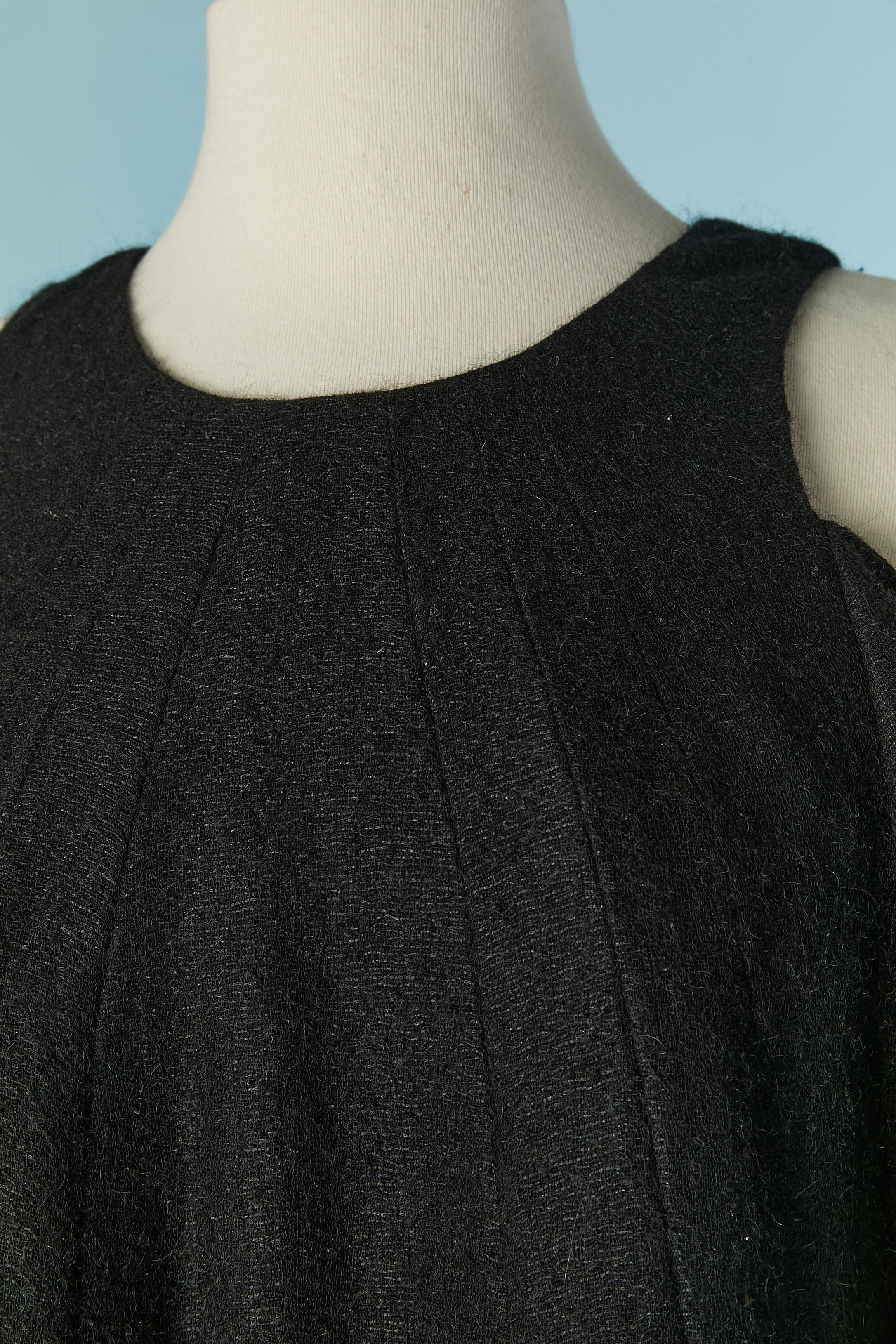 Abito in maglia di lana nera. Composizione della maglia: 68% lana, 21% mohair, 11% poliammide. 
Fodera in seta. 
Chiusura con zip e gancio sulla parte centrale della schiena. 
TAGLIA 38 (Fr) M 