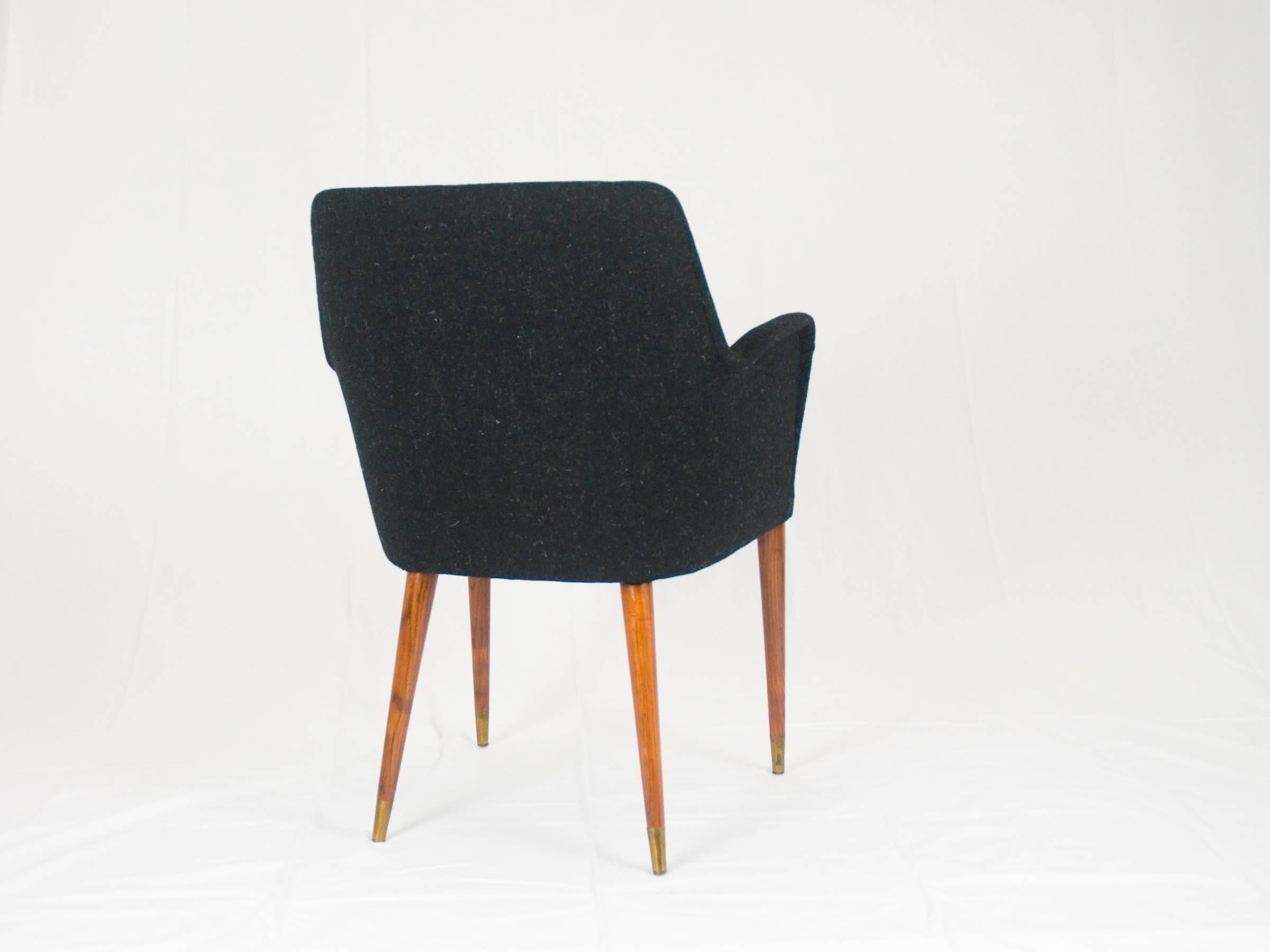 This P35 armchair is made from walnut and fabric upholstery: the four legs are equipped with their original brass tips. The chair has been upholstered with a brand new, but vintage wool fabric.