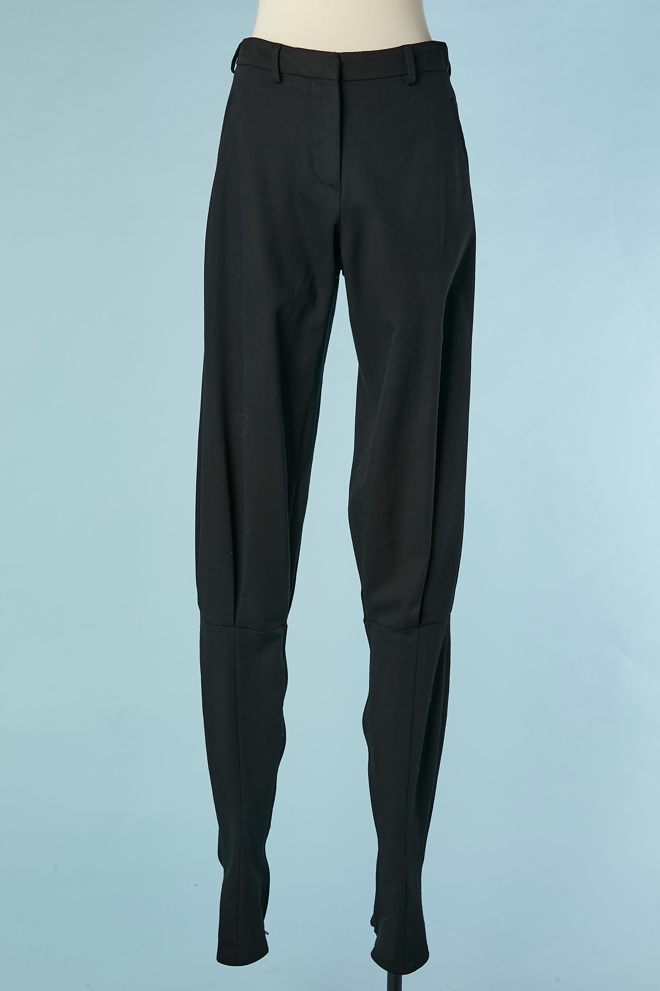 Black wool patered trouser with elastic band under the feet. Zip and hook&eye closure on the top middle front. Zip on both leg on the inside seam from the knee until the bottom edge. Pockets on both side.
SIZE 38 (Fr) 8 (Us) M 