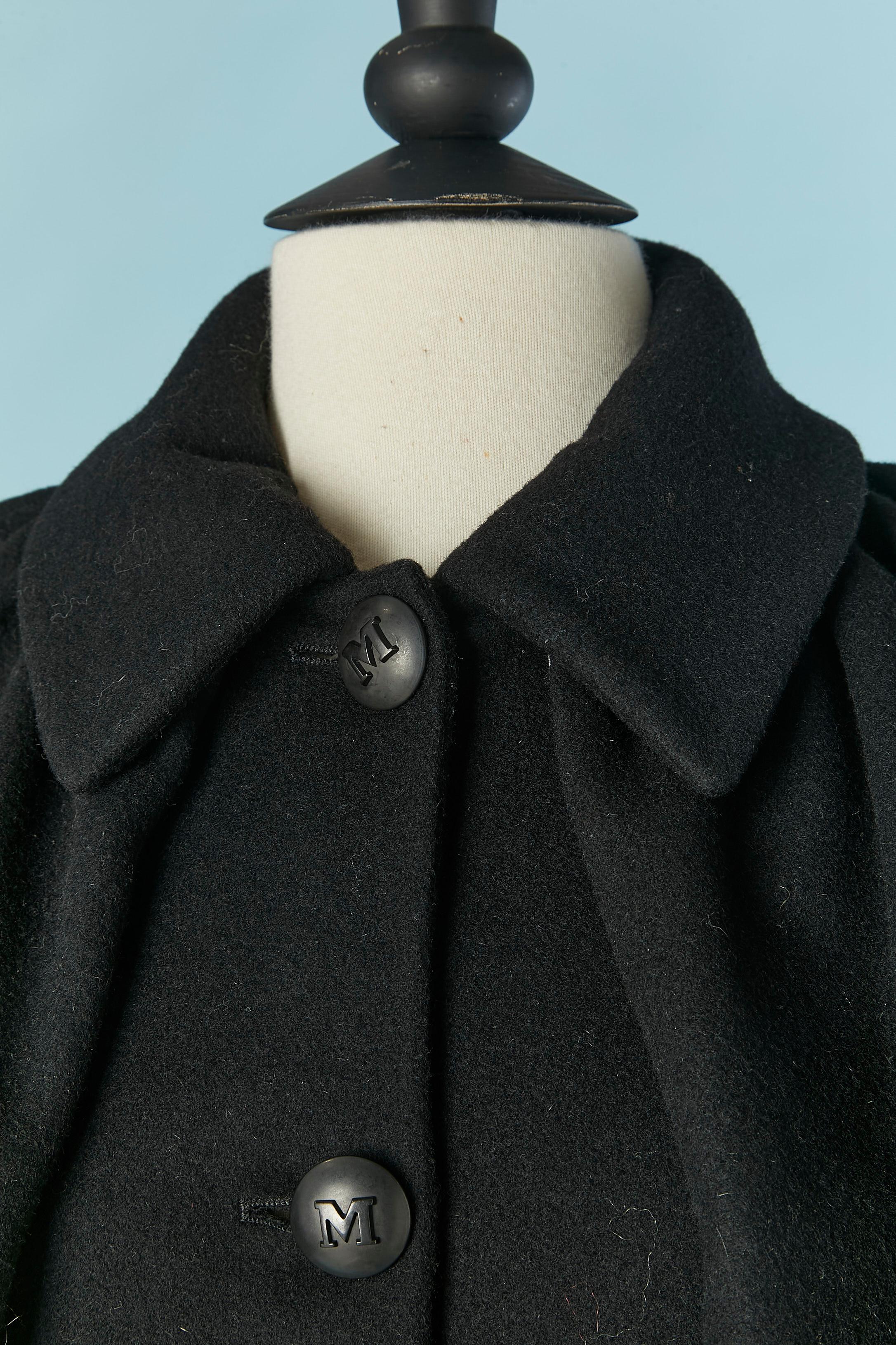 Einreihige schwarze Wolljacke mit doppeltem Umhang. Zusammensetzung des Hauptgewebes: 72% Wolle, 19% Angora, 7% Kaschmir, 2% Elastan. Bedrucktes Seidenfutter. Markenknopf und Knopflochverschluss in der vorderen Mitte.
SIZE 42 (It) 38 (Fr) M 