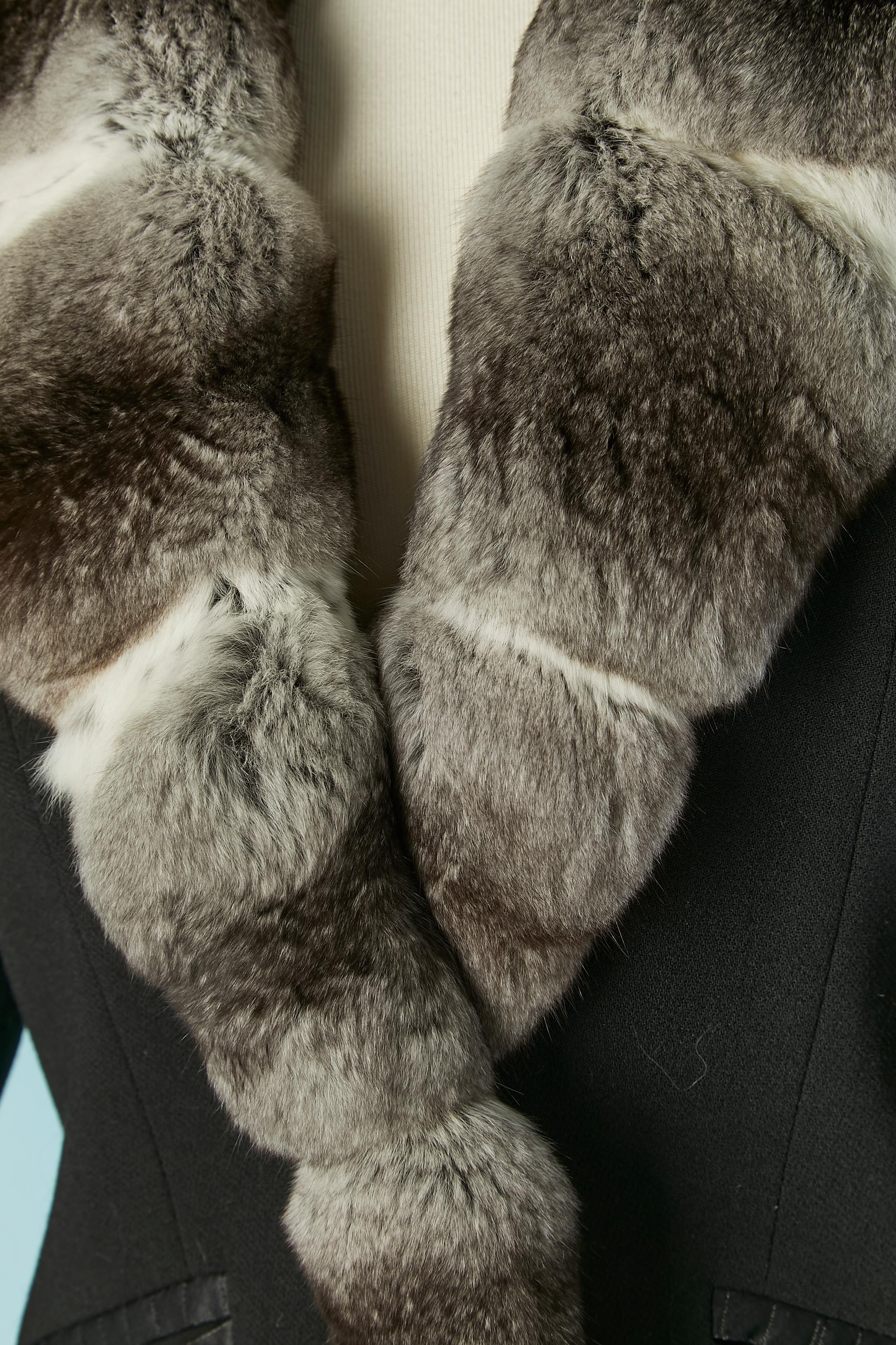 Black wool single breasted jacket with fur collar and cuffs. Lining composition: 100% bemberg. One button and buttonhole closure on the middle front + 3 buttons on each cuffs. Pocket on both side with the edge of the pocket made of top-stitched