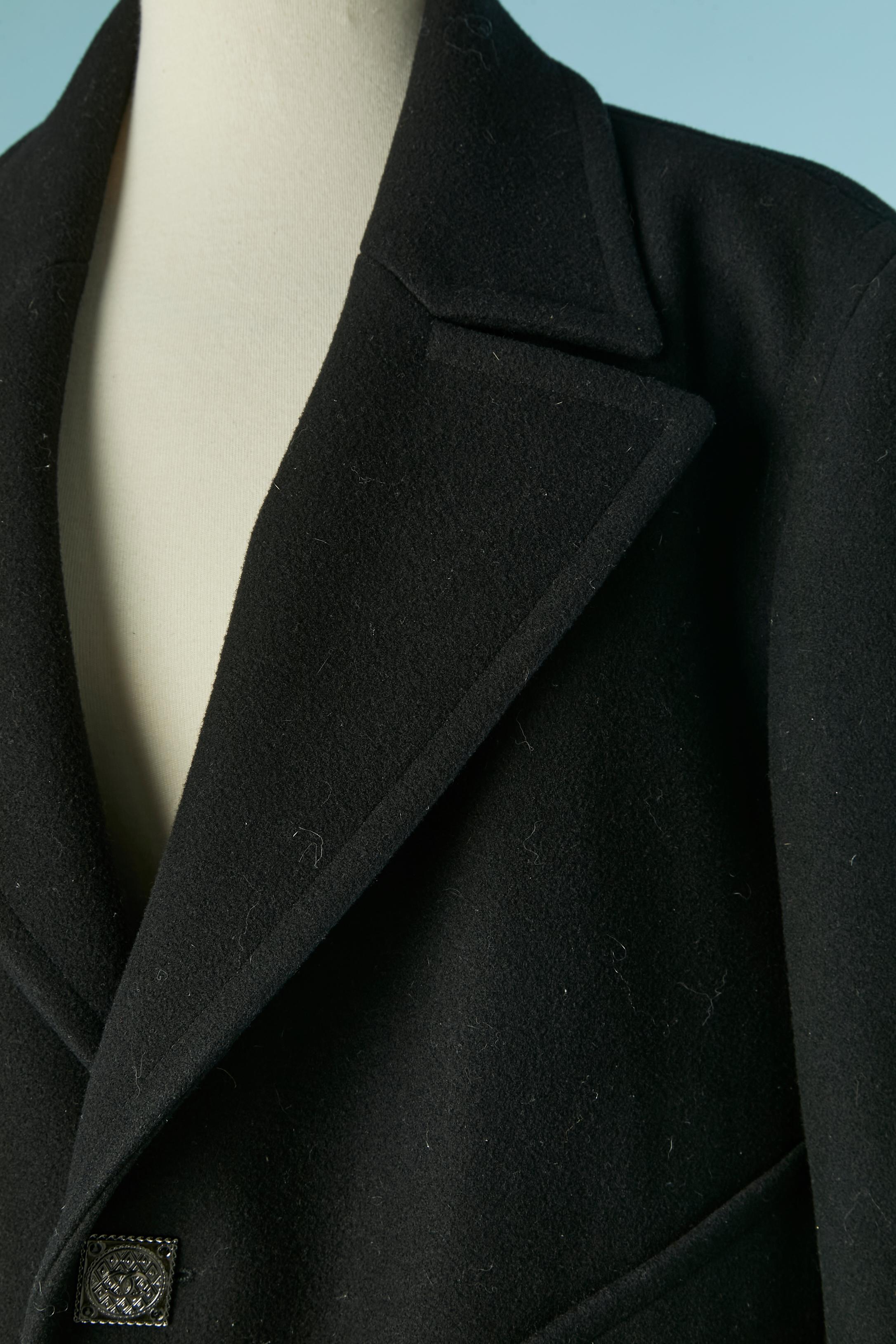 Caban en laine noire à simple boutonnage . Doublure en soie. Pad d'épaule. Bouton et boutonnière marqués sur le milieu du devant et sur les poignets. Pochette sur les deux côtés. 
Les Métiers d'Art Paris-Bizance 2011 / Des hommes en manteau mais