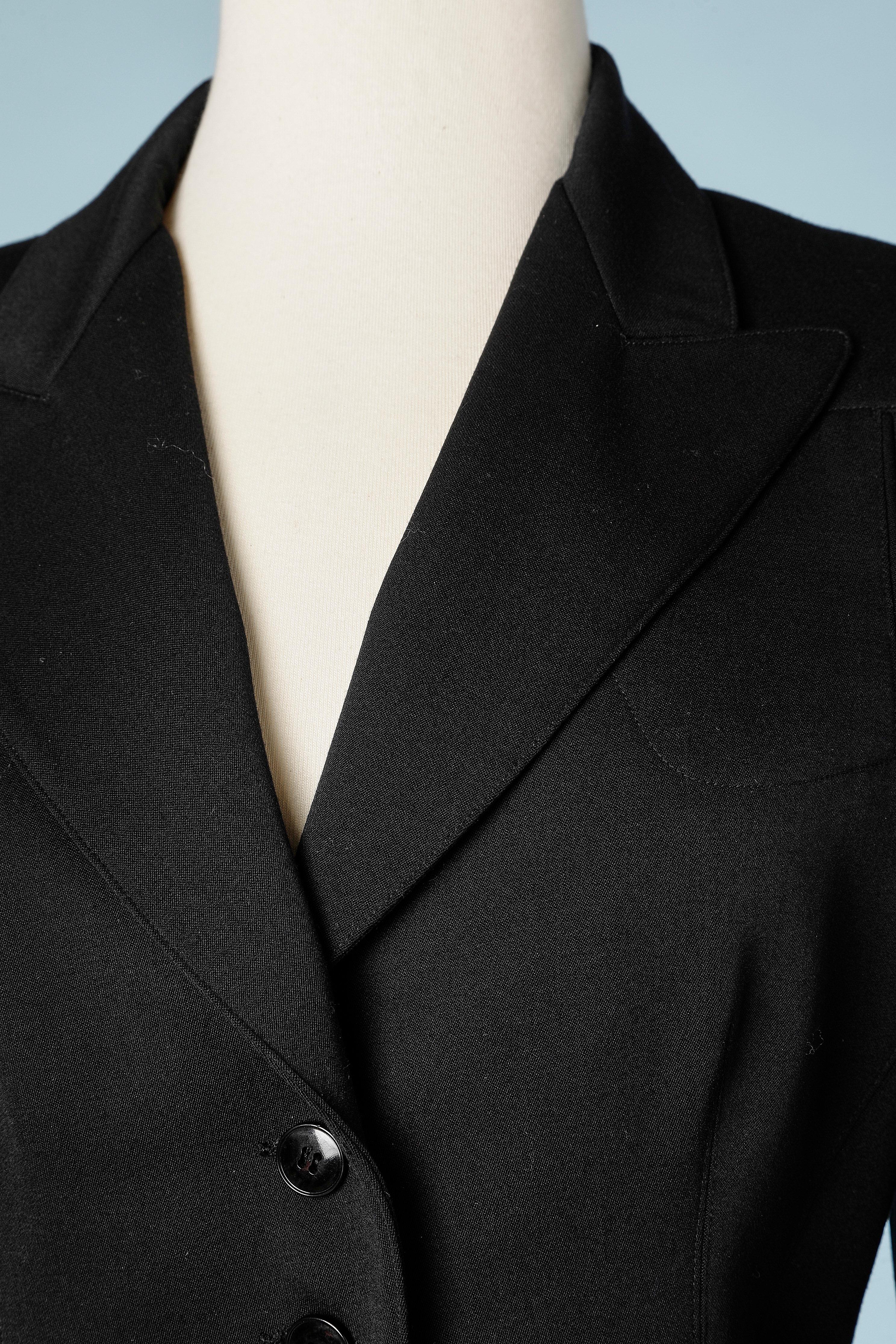 Black wool skirt-suit. Single breasted jacket and buttoned skirt. 
Shoulders pads.
SIZE 38 (M) 