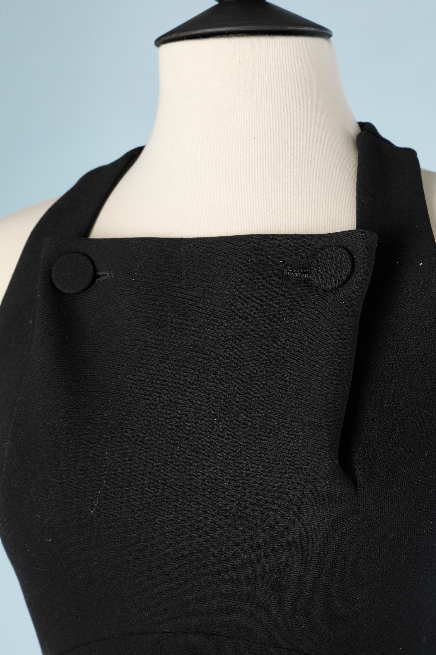 Black wool  sleeveless dress with 2 ornemental buttons and cut under the bust and on both side on the waist . Bottom part in biais 