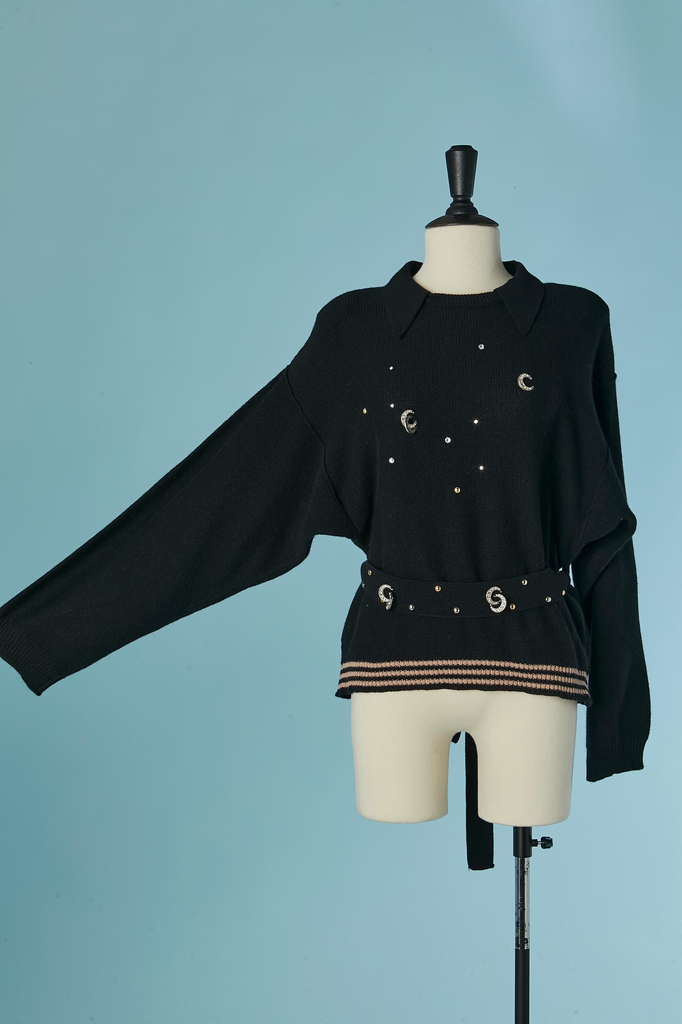 Black wool sweater with rhinestone, studs and metal moon embellishment. 
Knit belt with embellishments. Shoulder-pad. Belt-loop. 
SIZE L 