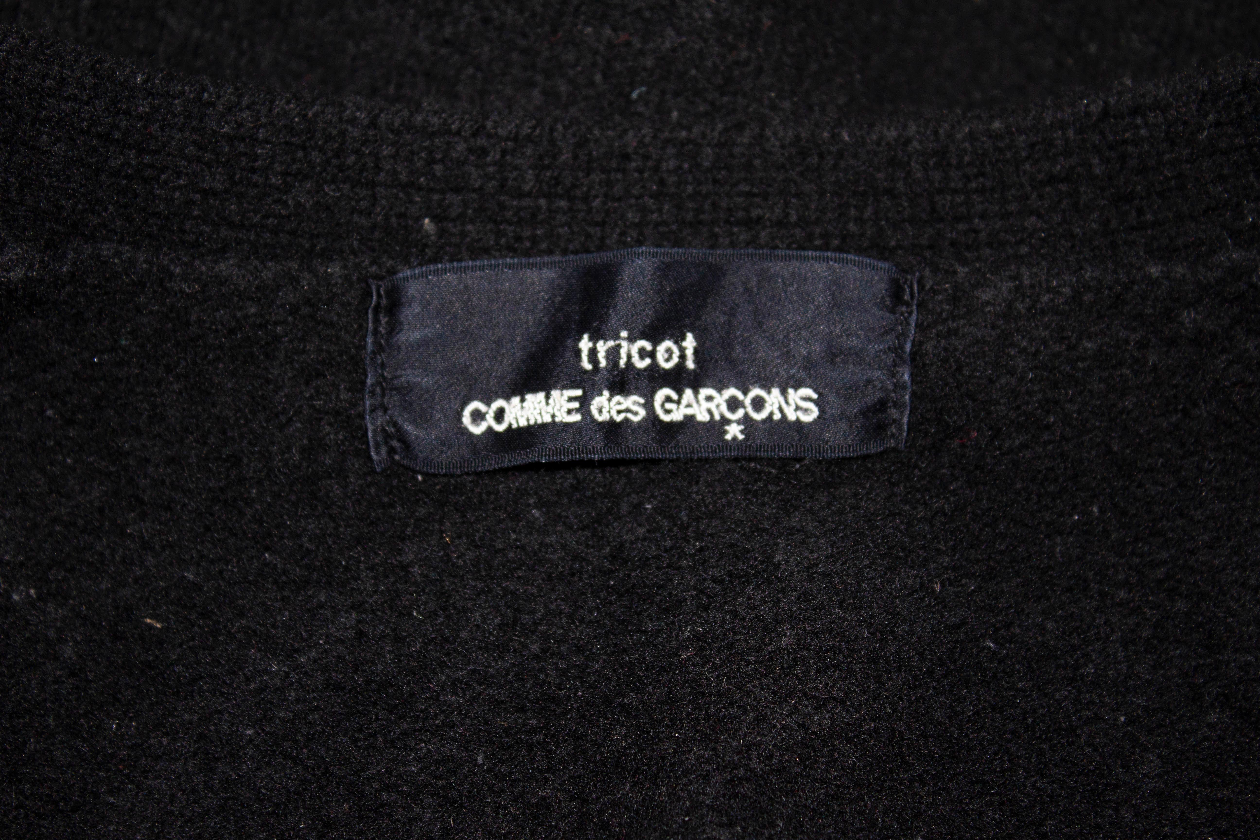 A chic black wool cardigan by Comme des Garcons. The cardigan has a v neckline and pockets on the front. 100 % wool , measurements: Bust 36'', length 27''