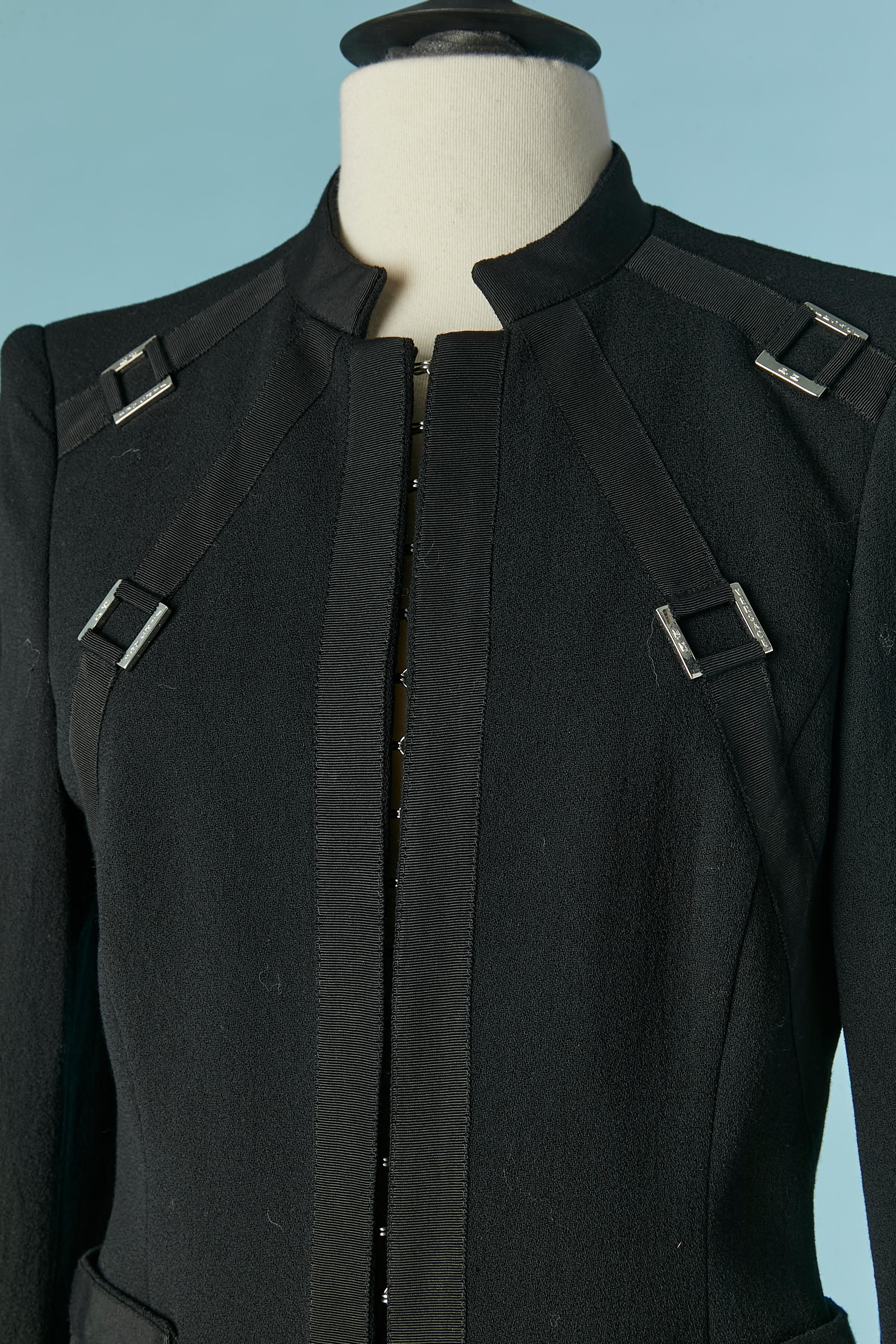 Combinaison-pantalon en laine noire. Doublure en rayonne. 
Pad d'épaule. Fermeture auto-agrippante sur le milieu du devant + boucle en métal argenté de marque. Pochette sur les deux côtés.
TAILLE 40 (It) 36 (Fr) 