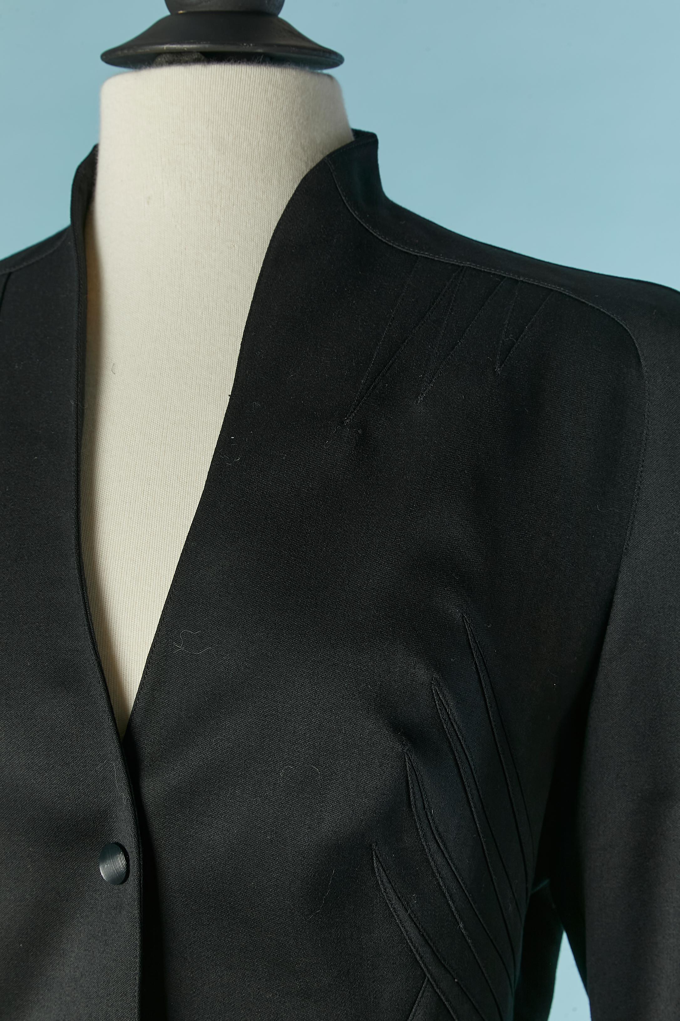 Black worsted wool skirt-suit with cut-work. No composition tag for the lining but probably rayon. Shoulder pad. Top-stitched cut-work. Snap closure on the middle front. Raglan sleeve. Pocket on both side. SIZE 38 (Fr) M 