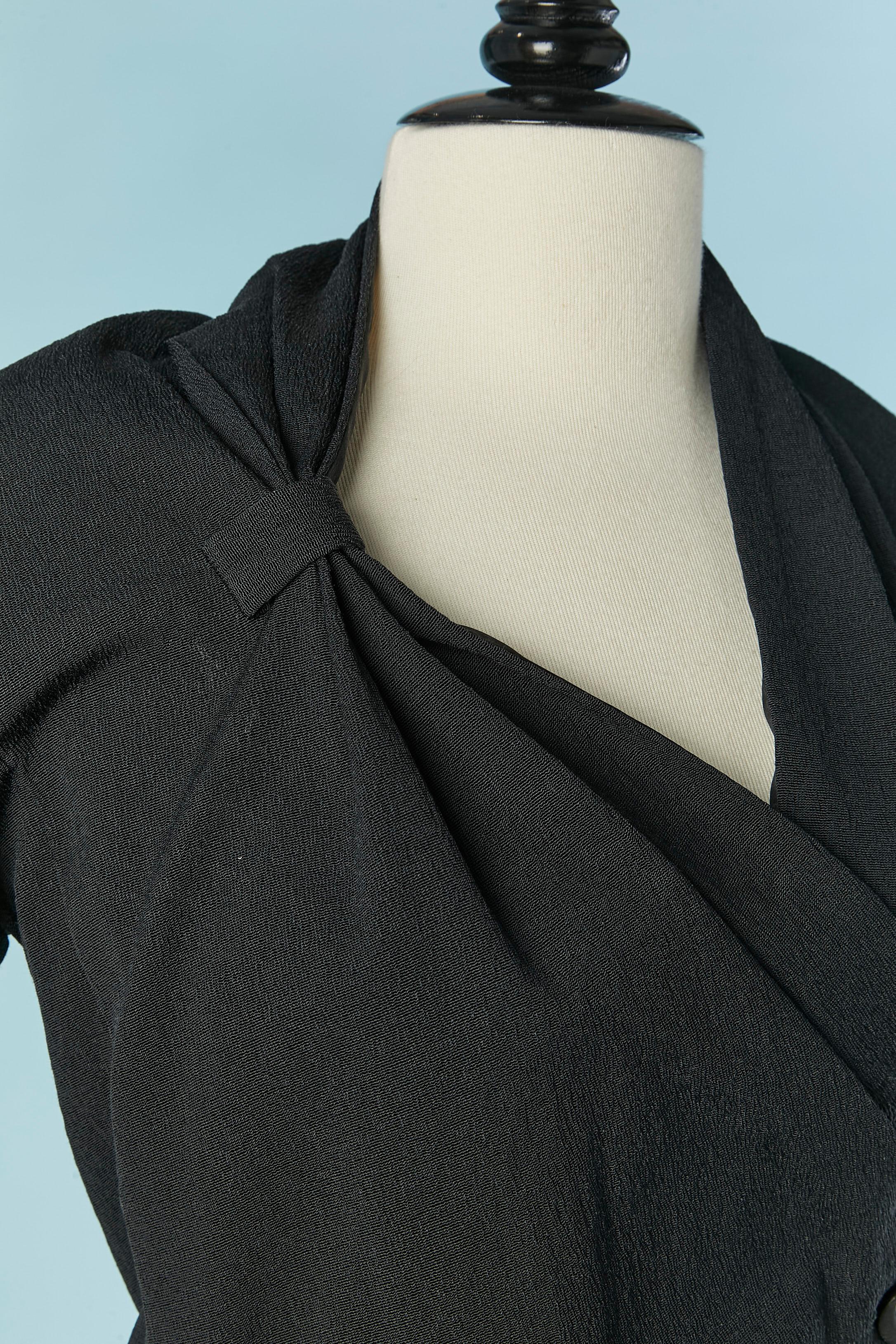 Chaqueta negra con borde de hilos de lana con chaleco debajo con cierre de cremallera . Composición del tejido: 57% rayón, 41% algodón, 2% elastán. Composición del forro: 94% seda, 6% elastán. 
Botón y ojal en el lado izquierdo + un corchete + un