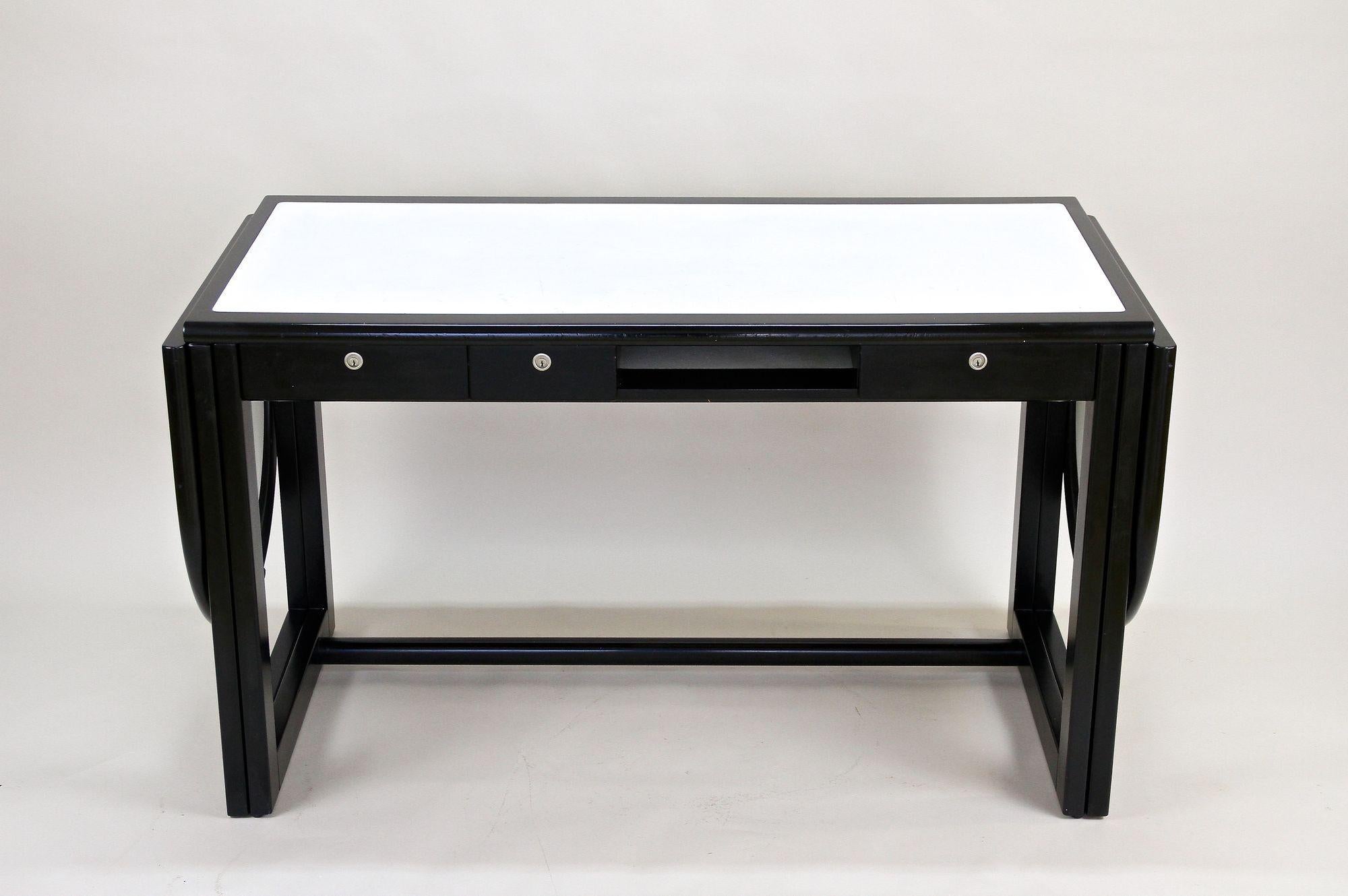 Fantastic black writing desk with white leather surface from the 1980s in Austria. Made by the renowed company of Thonet Austria, this contemporary office desk impresses with its extraordinary design, providing detachable flip-down leaves on each