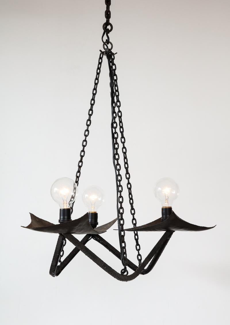 Black Wrought Iron Chandelier in the Manner of Raymond Subes, France, 20th Century

A small but striking gothic chandelier in hand-hammered wrought iron. The structure and cups show the hand of the craftsperson; beautifully textured. The small size